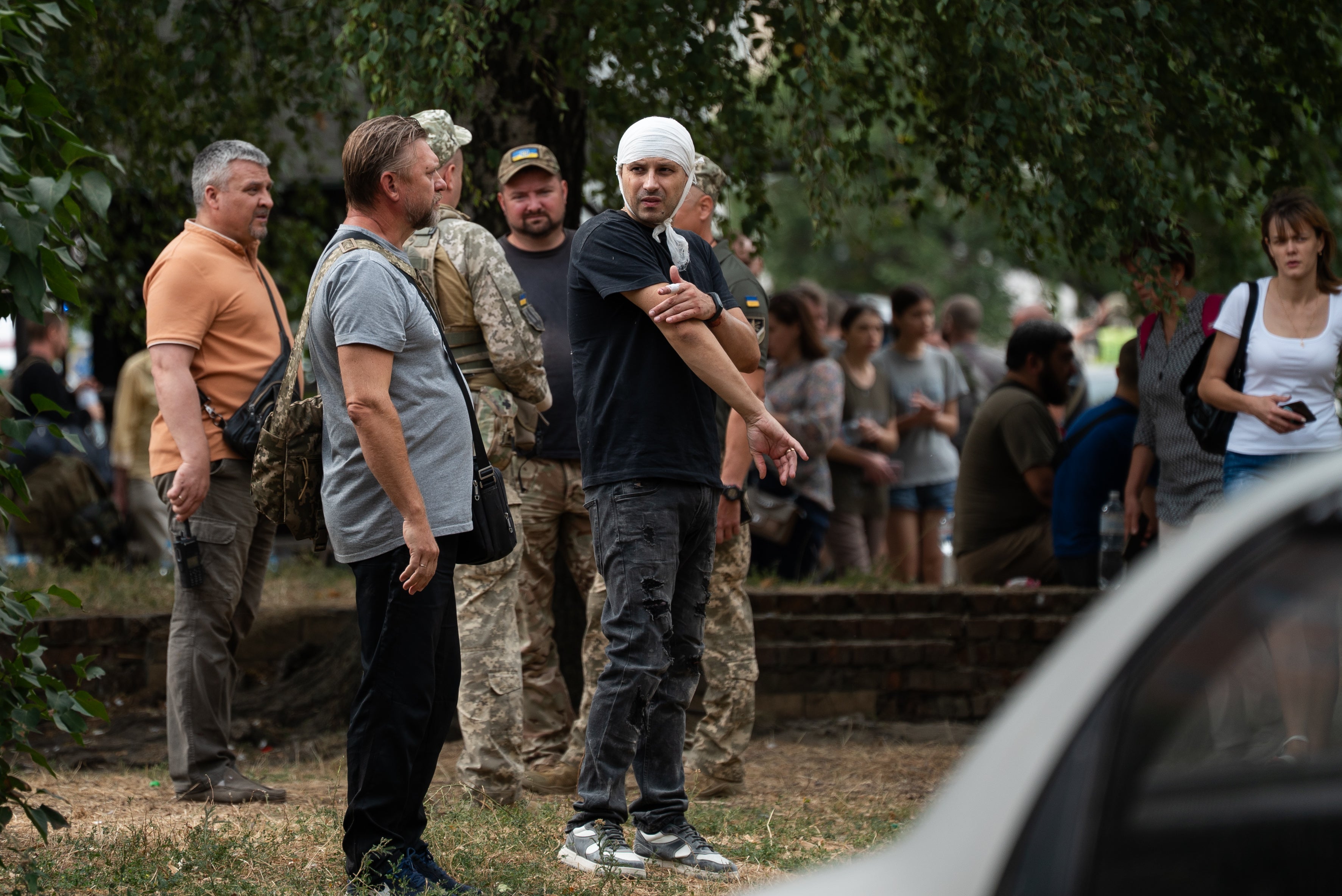 People stand in the street near the Poltava Military Institute of Communications after a Russian missile attack on Tuesday