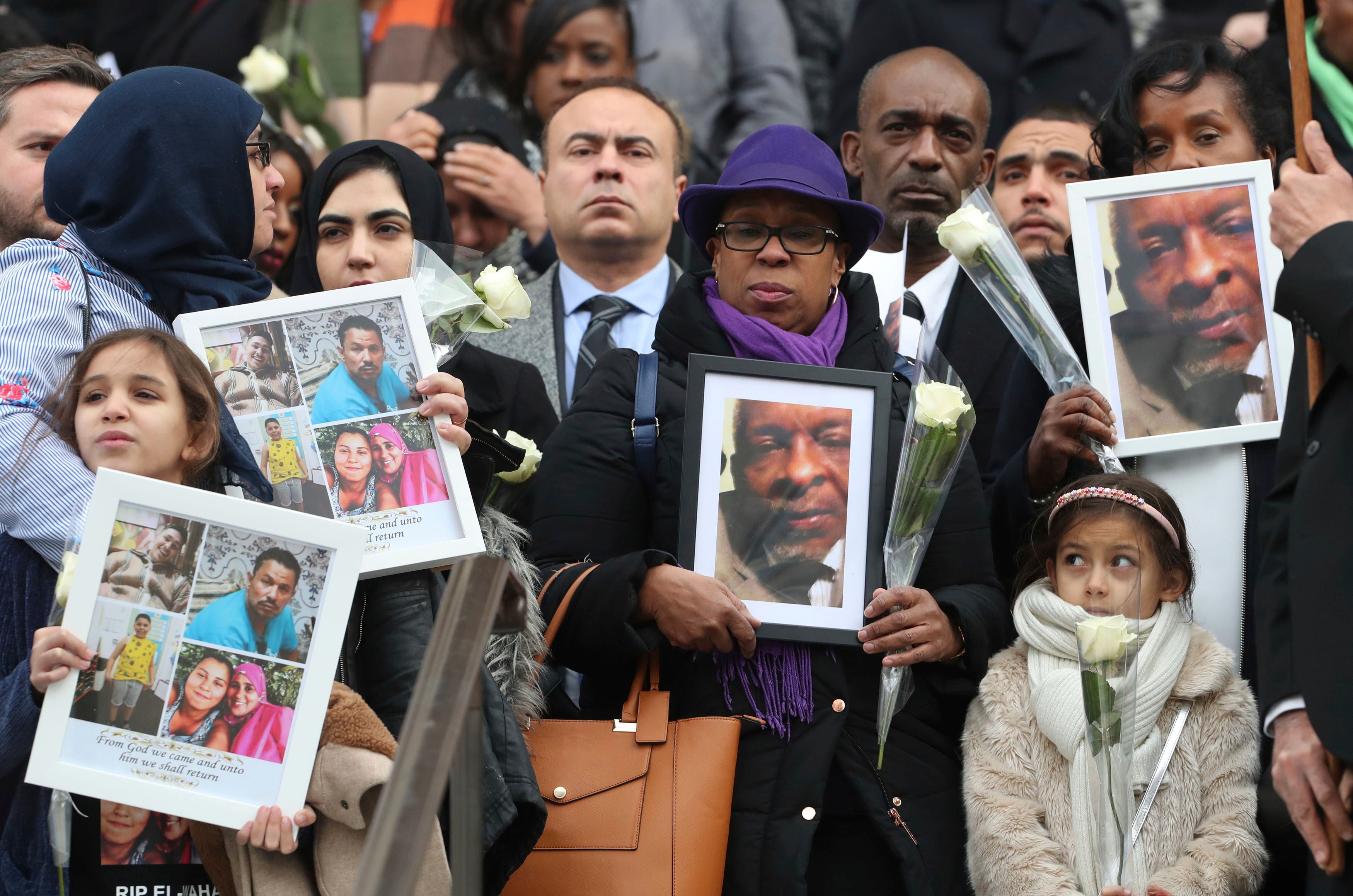 Survivors and local residents holding photographs of their missing or deceased loved ones