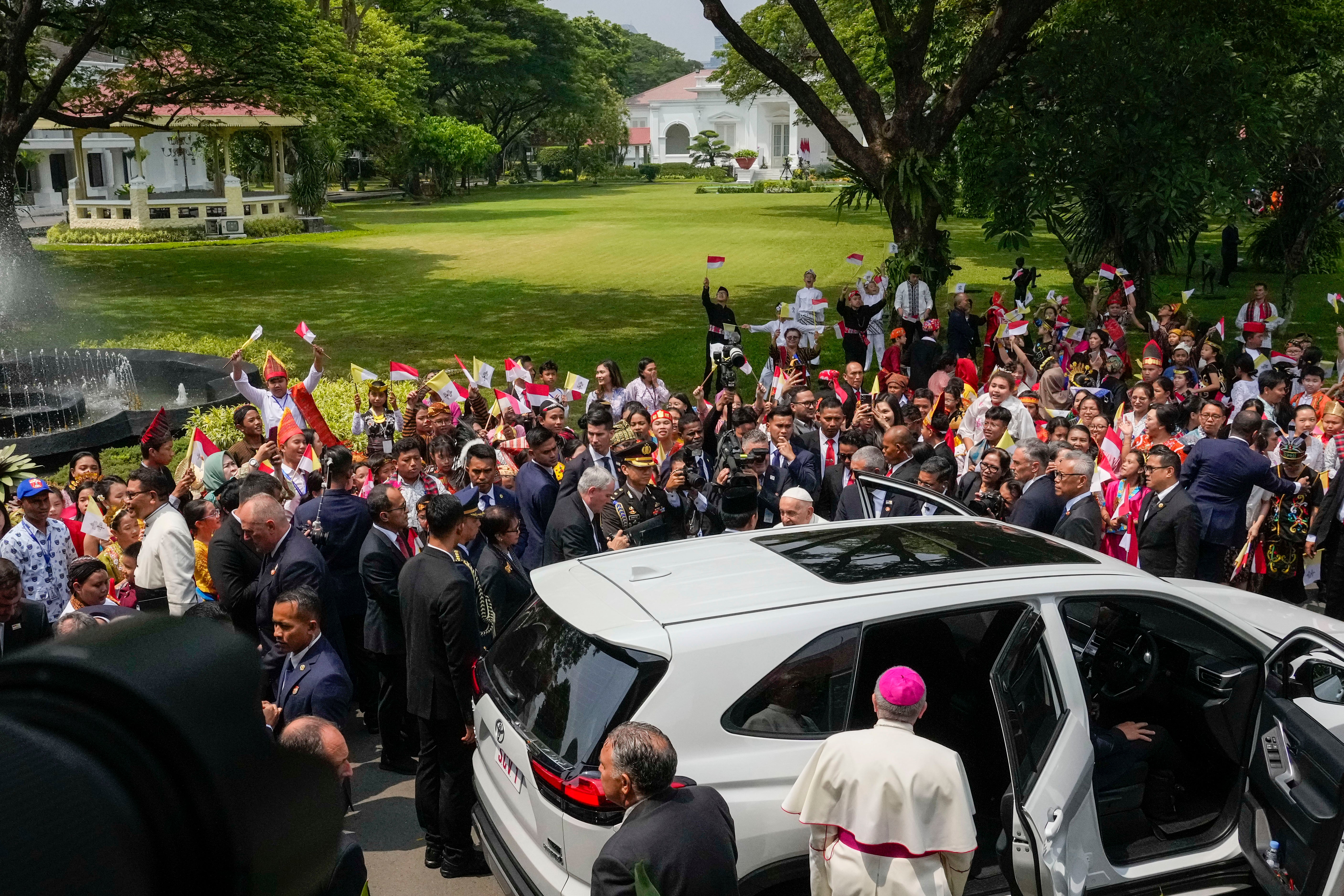 Pope Francis and Apostolic Nuncio to Indonesia Bishop Piero Pioppo (back to camera) leave after a meeting with Indonesian officials