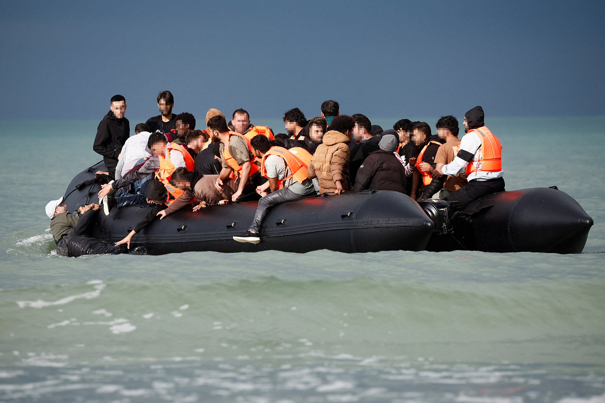 Migrants on an inflatable dinghy attempt to cross the English Channel to reach Britain, on the beach of the Slack dunes in Wimereux, France