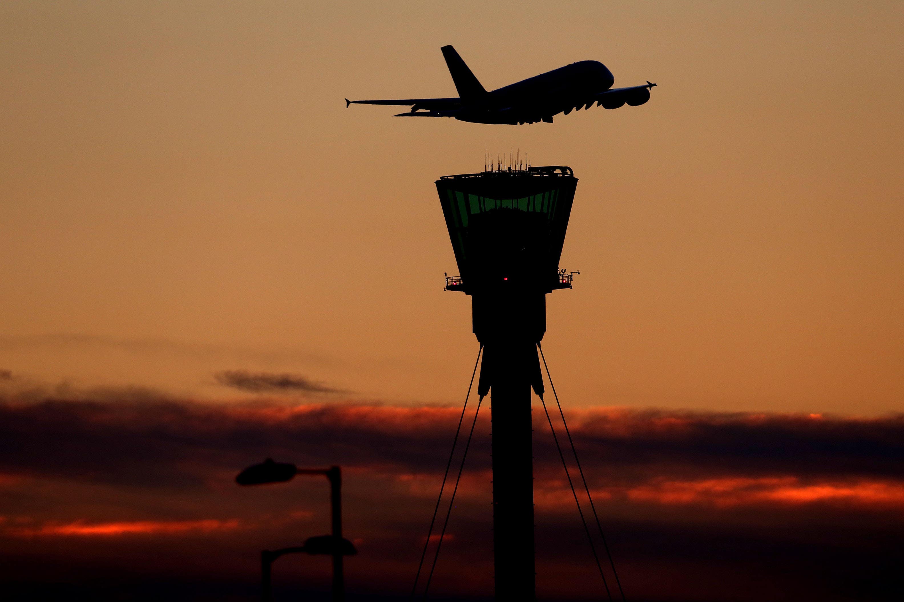 A plane leaves at sunset over Heathrow Airport (Steve Parsons/PA)