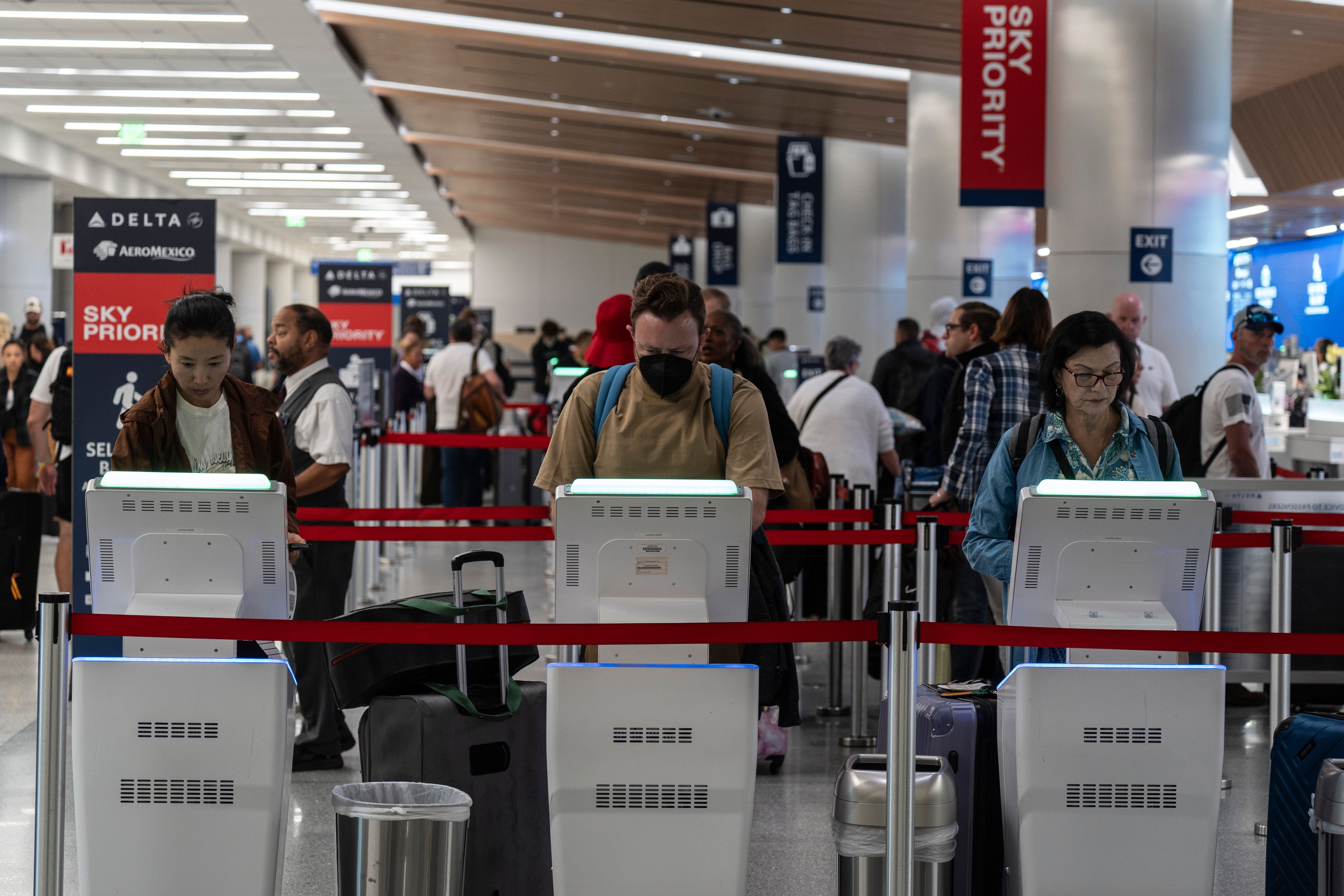 Travelers use kiosks to check in for flights in the Delta Airlines ticketing area at the Los Angeles International Airport in Los Angeles, Friday, Aug. 30, 2024