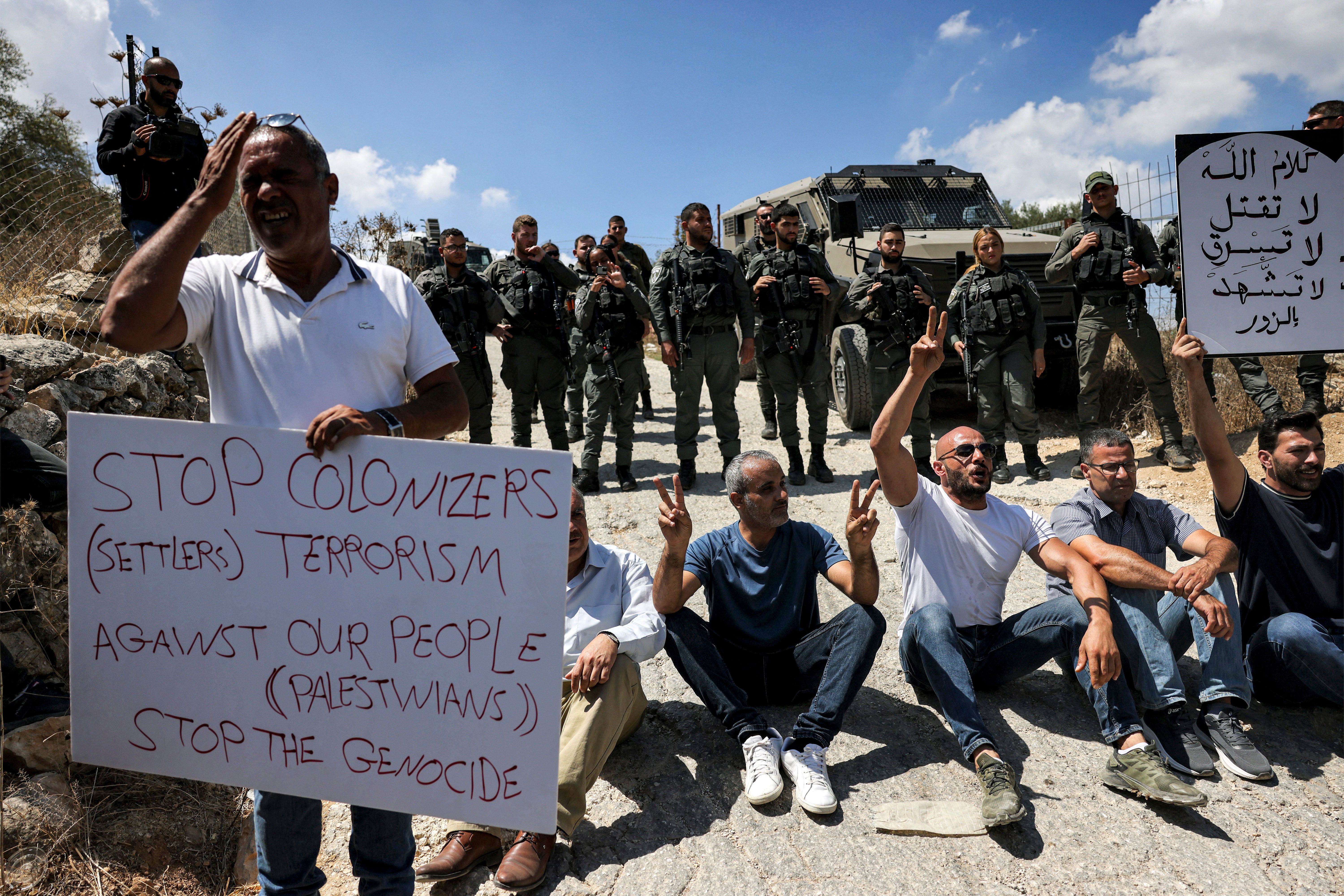 Demonstrators sit before Israeli border guards during a protest vigil in Beit Jala in the occupied West Bank this week