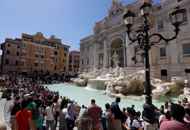 <p>Tourists admire the Trevi Fountain in Rome</p>