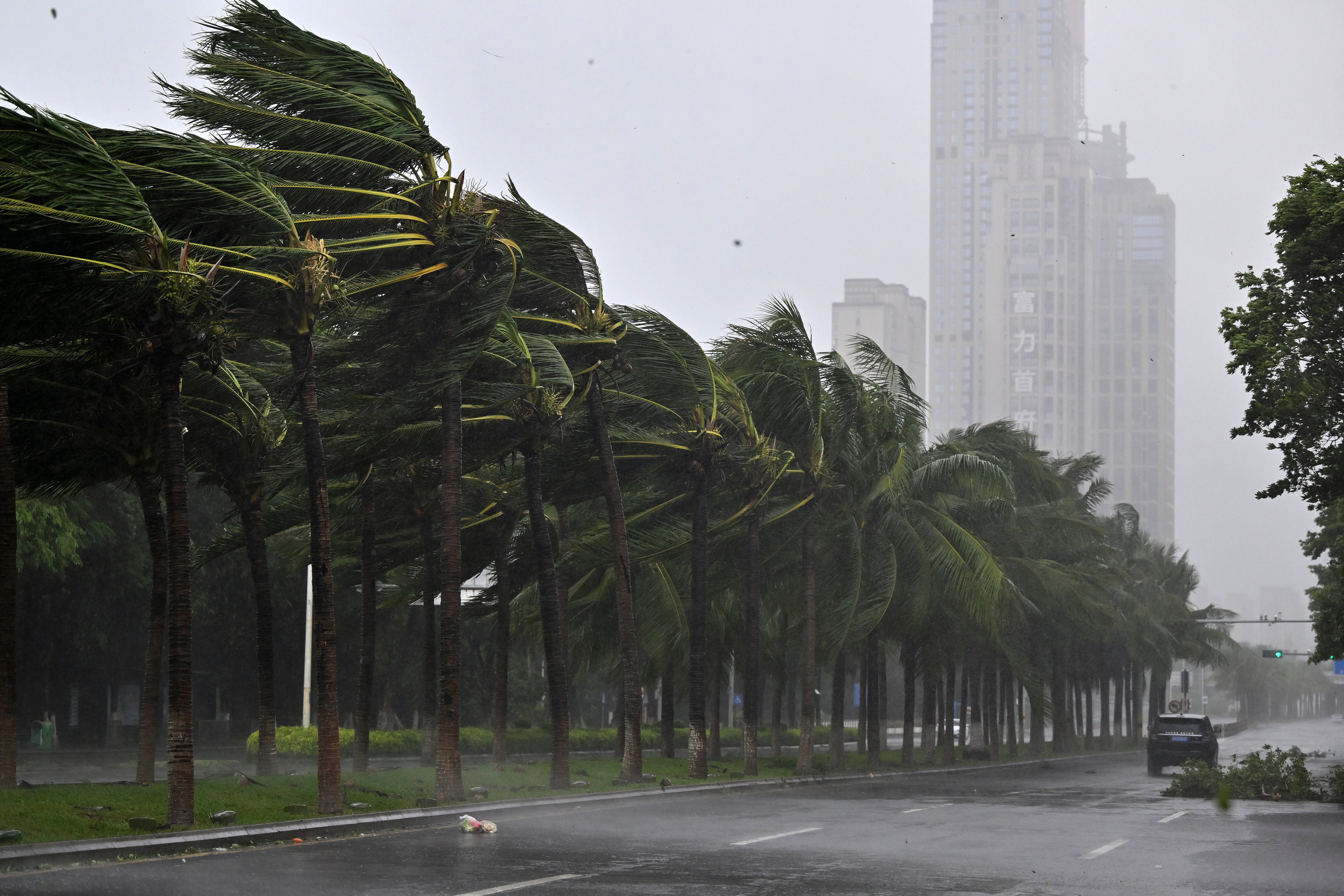 In this photo released by Xinhua News Agency, a vehicle moves past trees along a road in Haikou following the landfall of typhoon Yagi, in south China’s Hainan Province, Friday, 6 September 2024