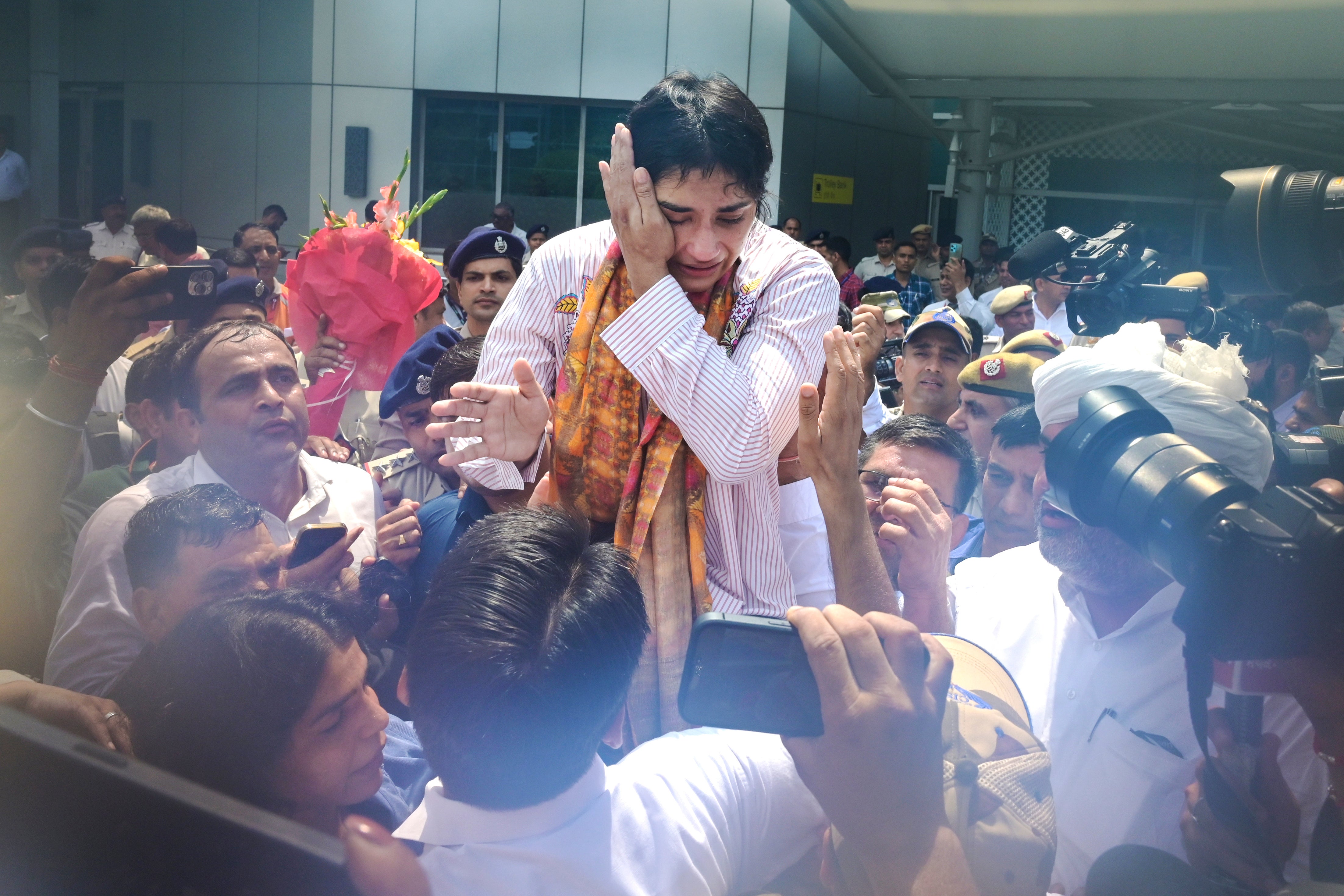 Indian wrestler Vinesh Phogat, who was disqualified from the women’s 50kg free-style final at the Paris Olympics for being 100g overweight, reacts as she is welcomed upon her arrival at the Indira Gandhi International Airport in New Delhi, India, Saturday, 17 August 2024