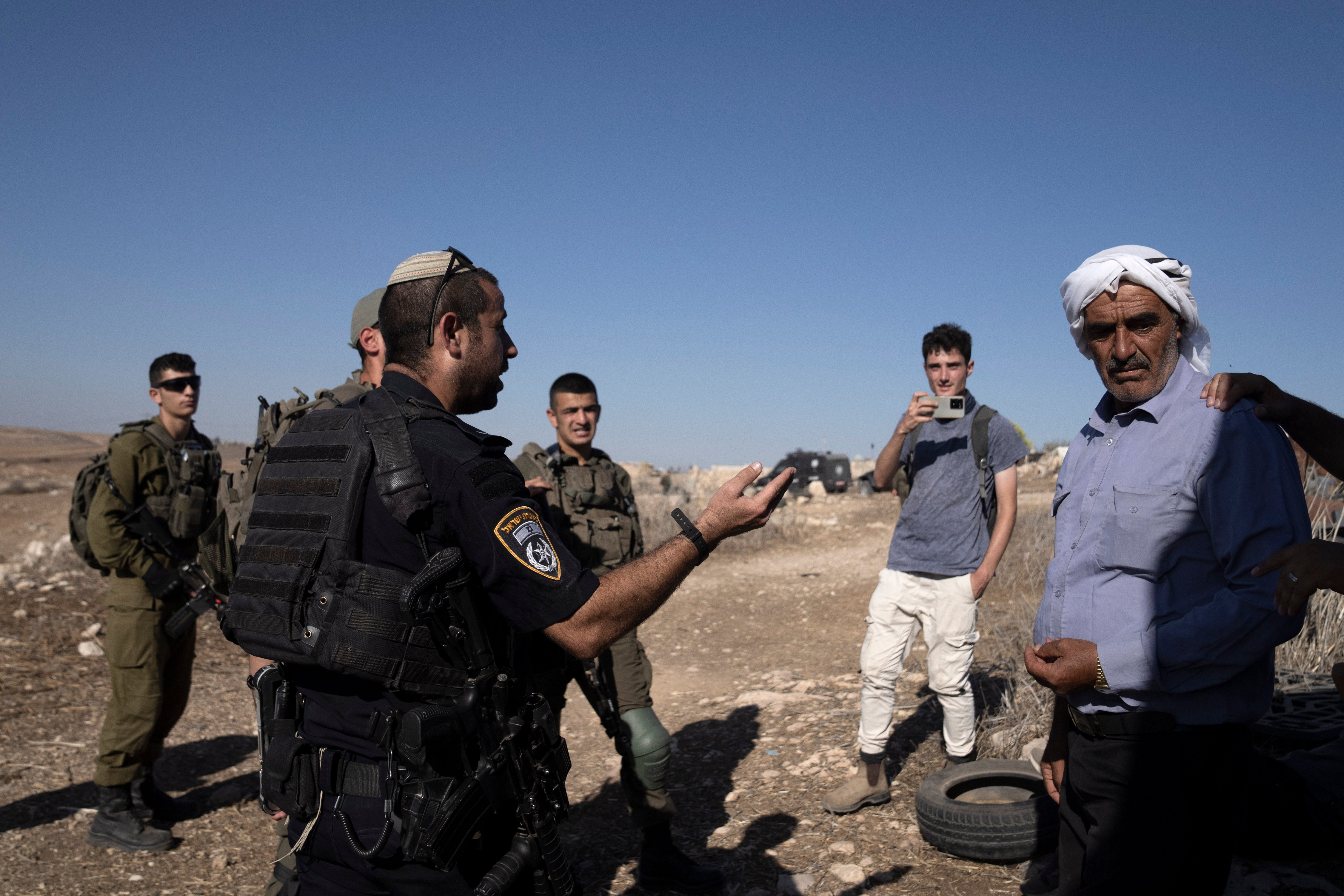 Israeli Police speak to residents of the West Bank village of Khirbet Zanuta, after activists called to report Israeli setters in the village