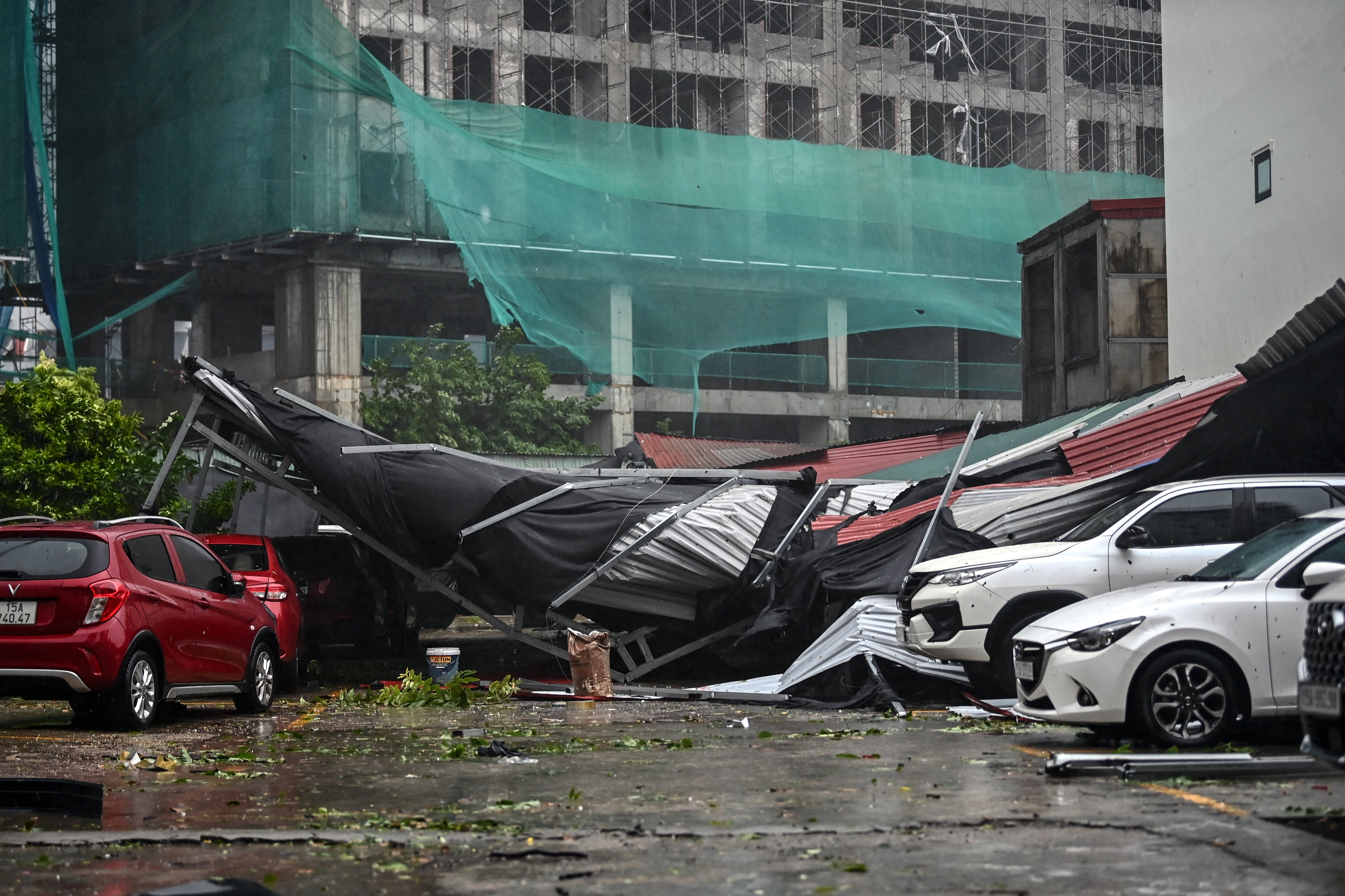 Cars are covered in debris at a parking lot after Super Typhoon Yagi hit Hai Phong on September 7, 2024