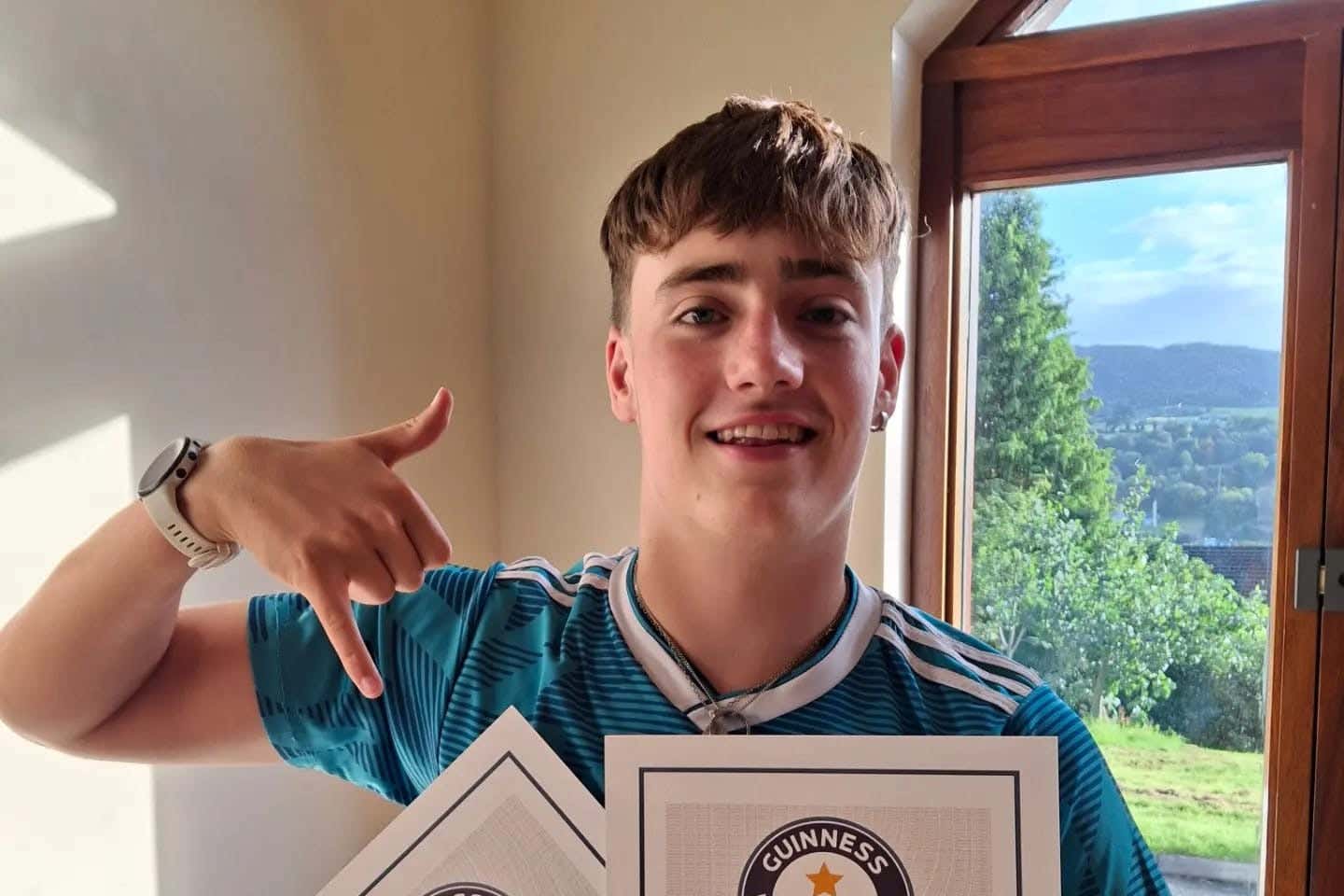 Distance swimmer Daniel Smyth from Newry with his certificate after becoming the youngest person to swim the North Channel from Donaghadee in Co Down to Portpatrick in Scotland (Elena Smyth/PA)