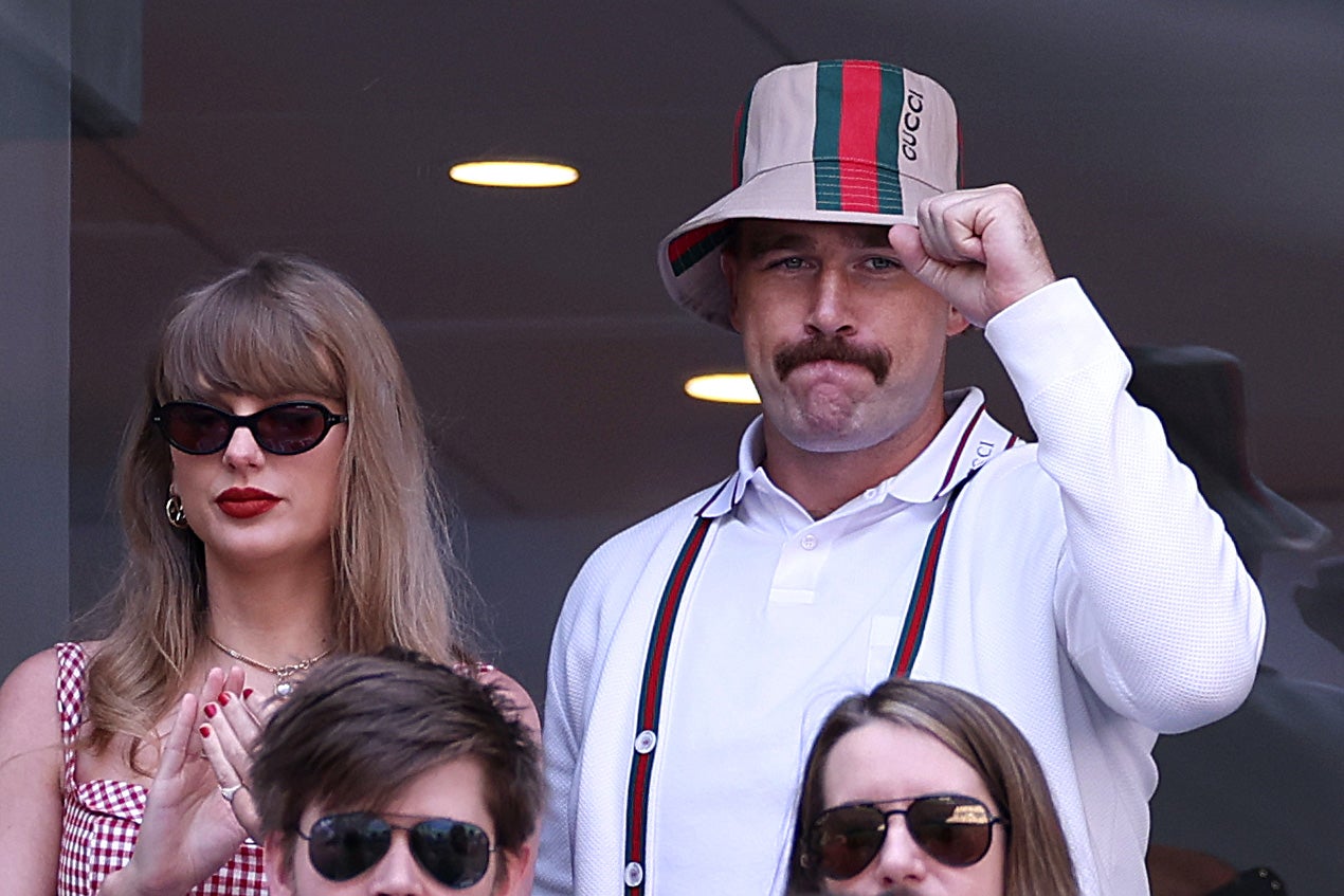 Swift was wearing a red and white checkerboard dress, while her boyfriend was sporting a tan Gucci bucket hat