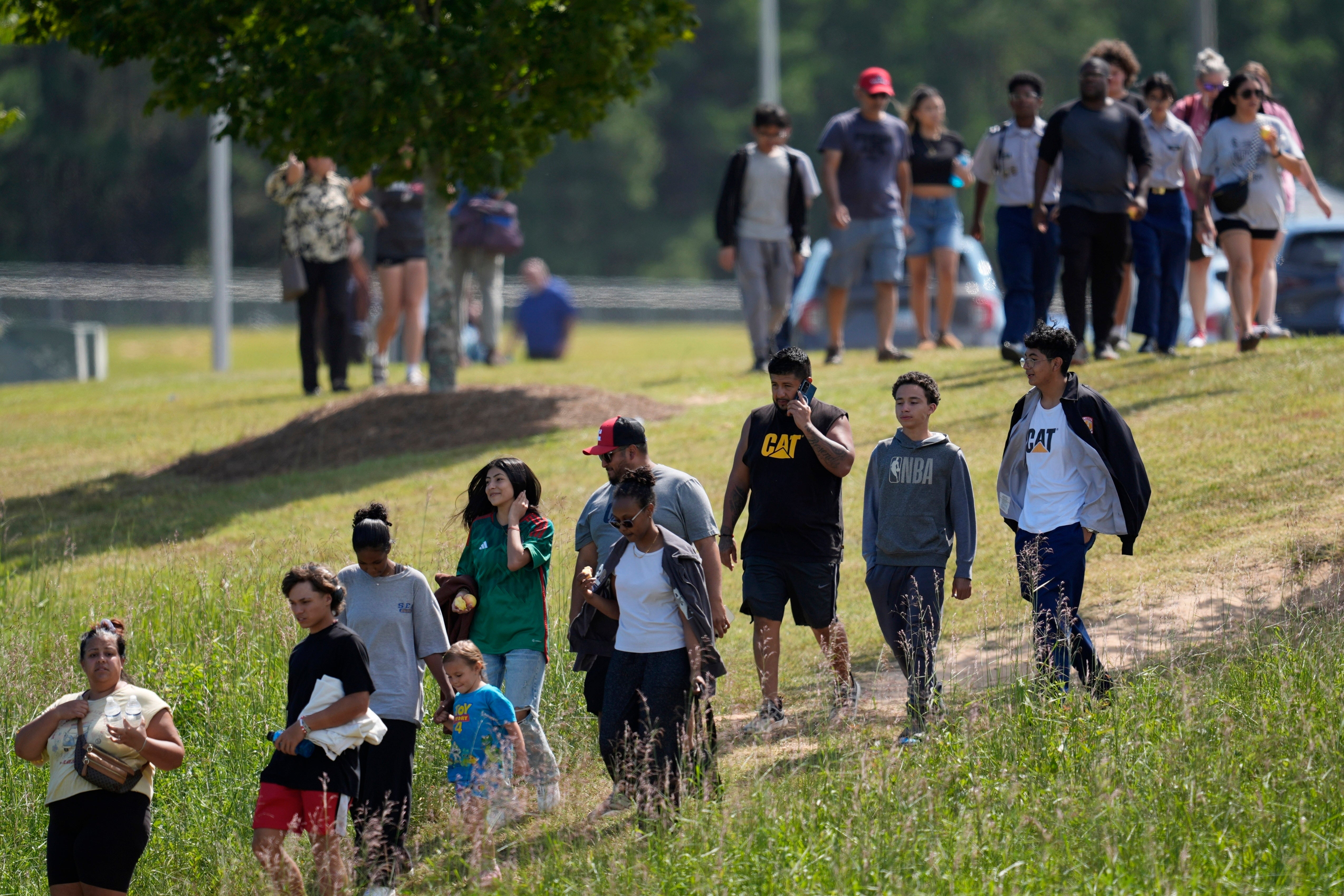 Students and parents walk off campus at Apalachee High School after a shooting at the school, Wednesday, Sept. 4, 2024, in Winder, Georgia