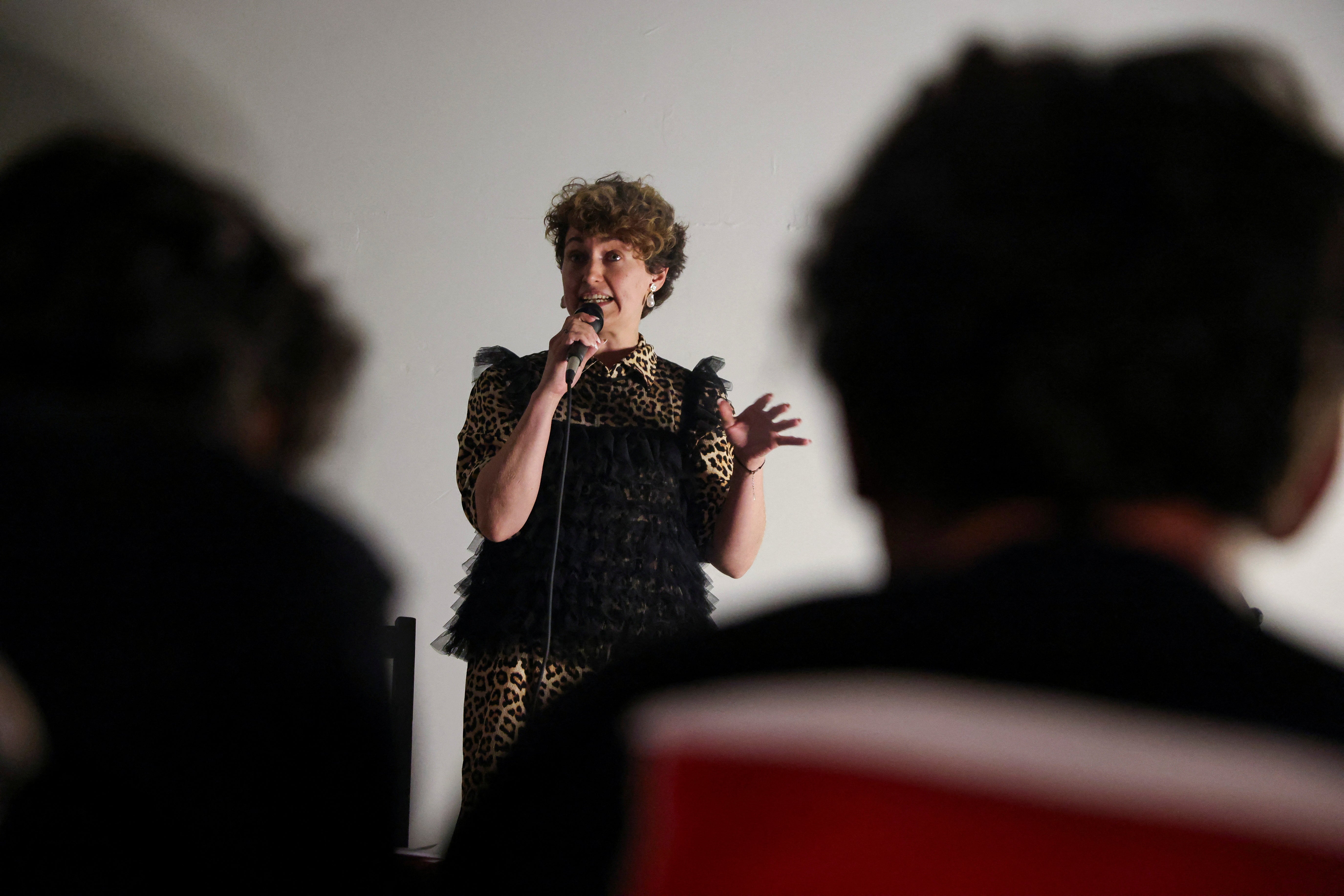 A Russian stand-up comedian tells jokes to a predominantly Russian audience in Belgrade