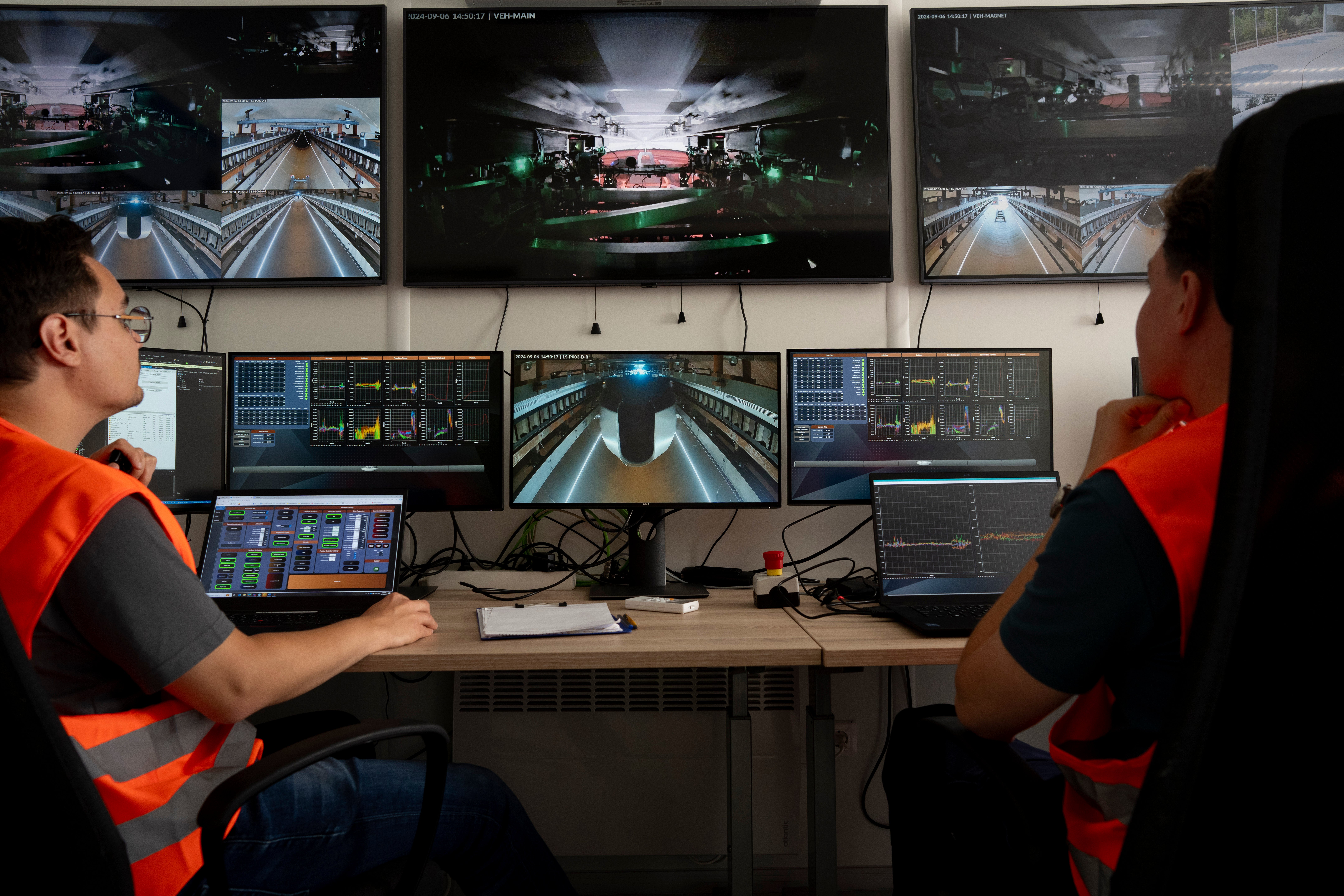 Technicians work in the control room at a testing ground for a high-speed transit system