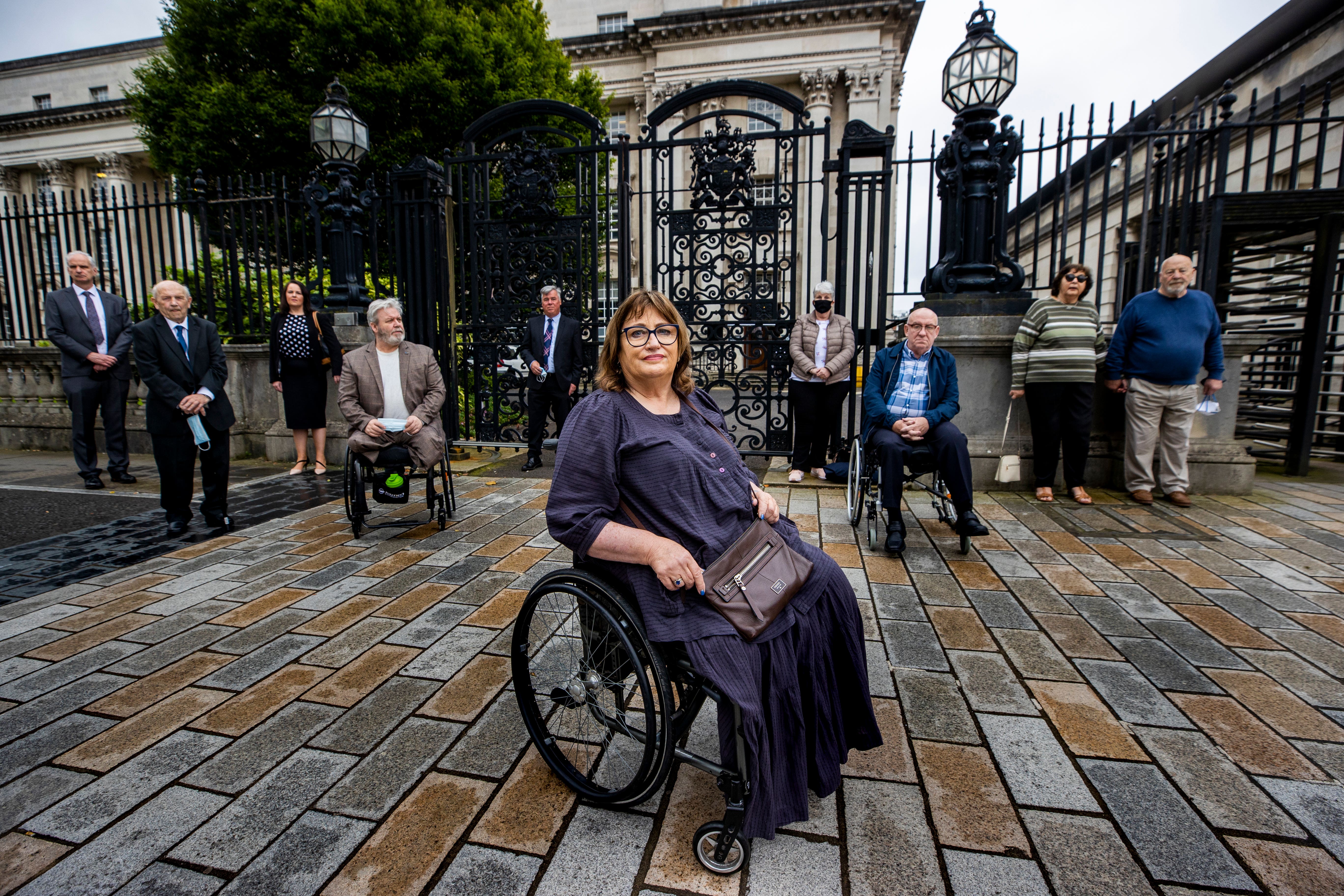 Jennifer McNern, who lost both legs in the Abercorn bombing, poses outside Belfast’s High Court with legal team and members of the Wave Trauma Centre to challenge delays over her Troubles pension (Liam McBurney/PA)