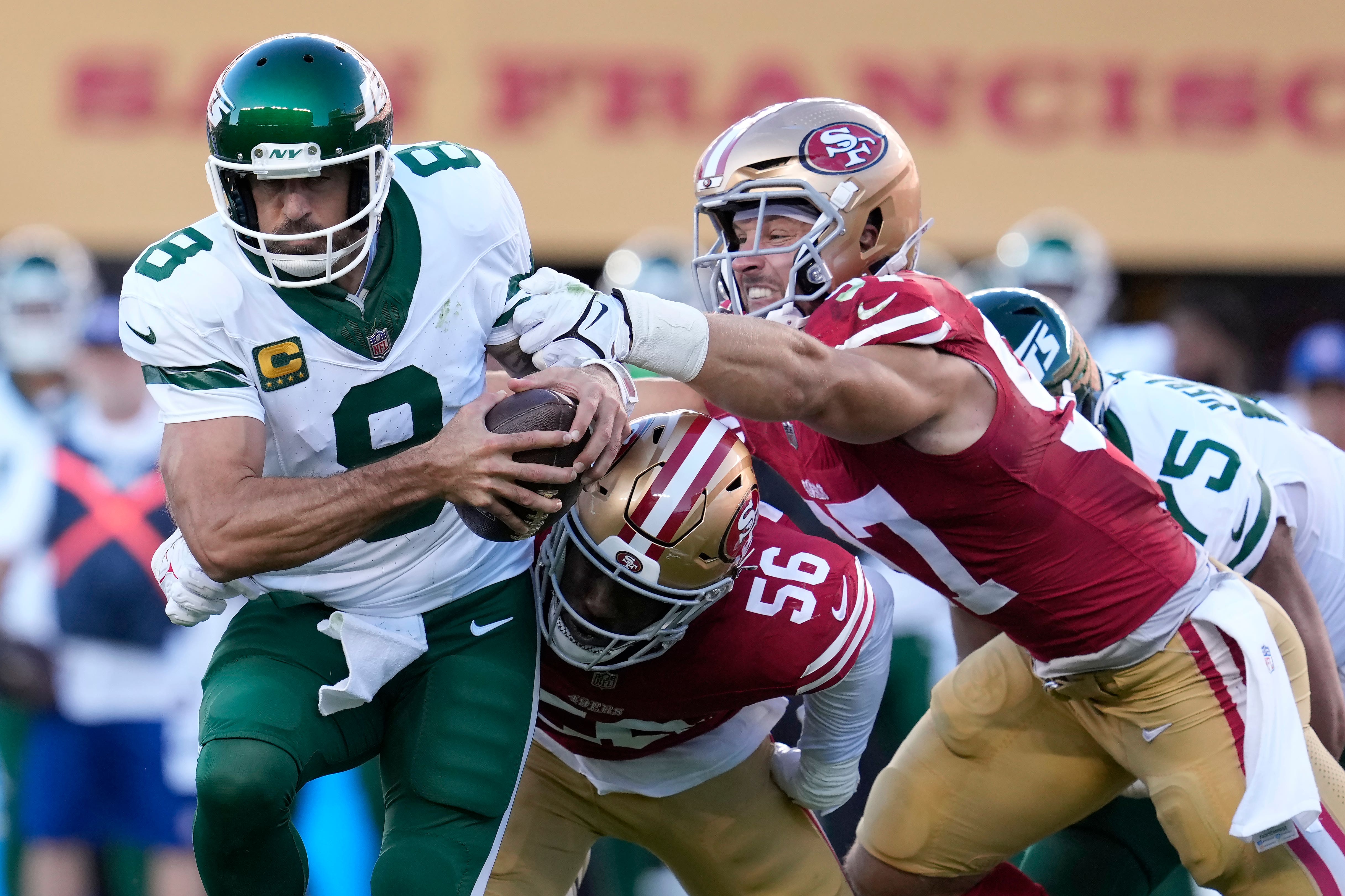 New York Jets quarterback Aaron Rodgers tries to scramble from San Francisco 49ers defensive end Leonard Floyd and defensive end Nick Bosa before being sacked (Godofredo A Vasquez/AP)