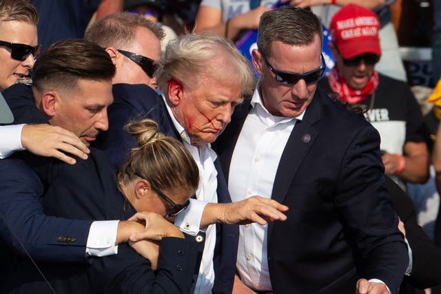 <p>Donald Trump is seen with blood on his face surrounded by Secret Service agents as he is taken off the stage in Butler, Pennsylvania. A new report says the Secret Service lacks “critical thinking” </p>