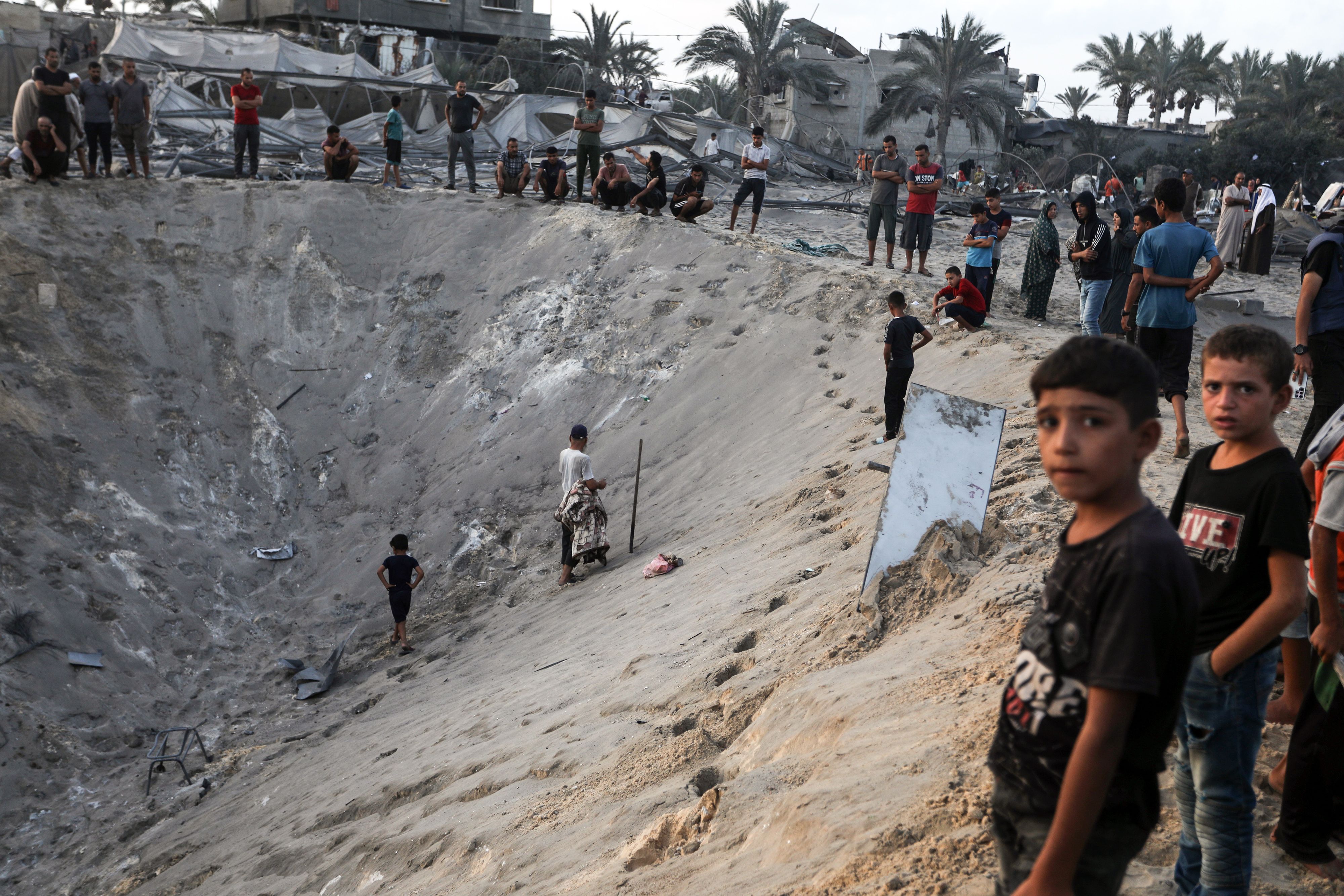 A huge crater left by Israeli strikes on a tent camp sheltering displaced people in the al-Muwasi area of Khan Younis