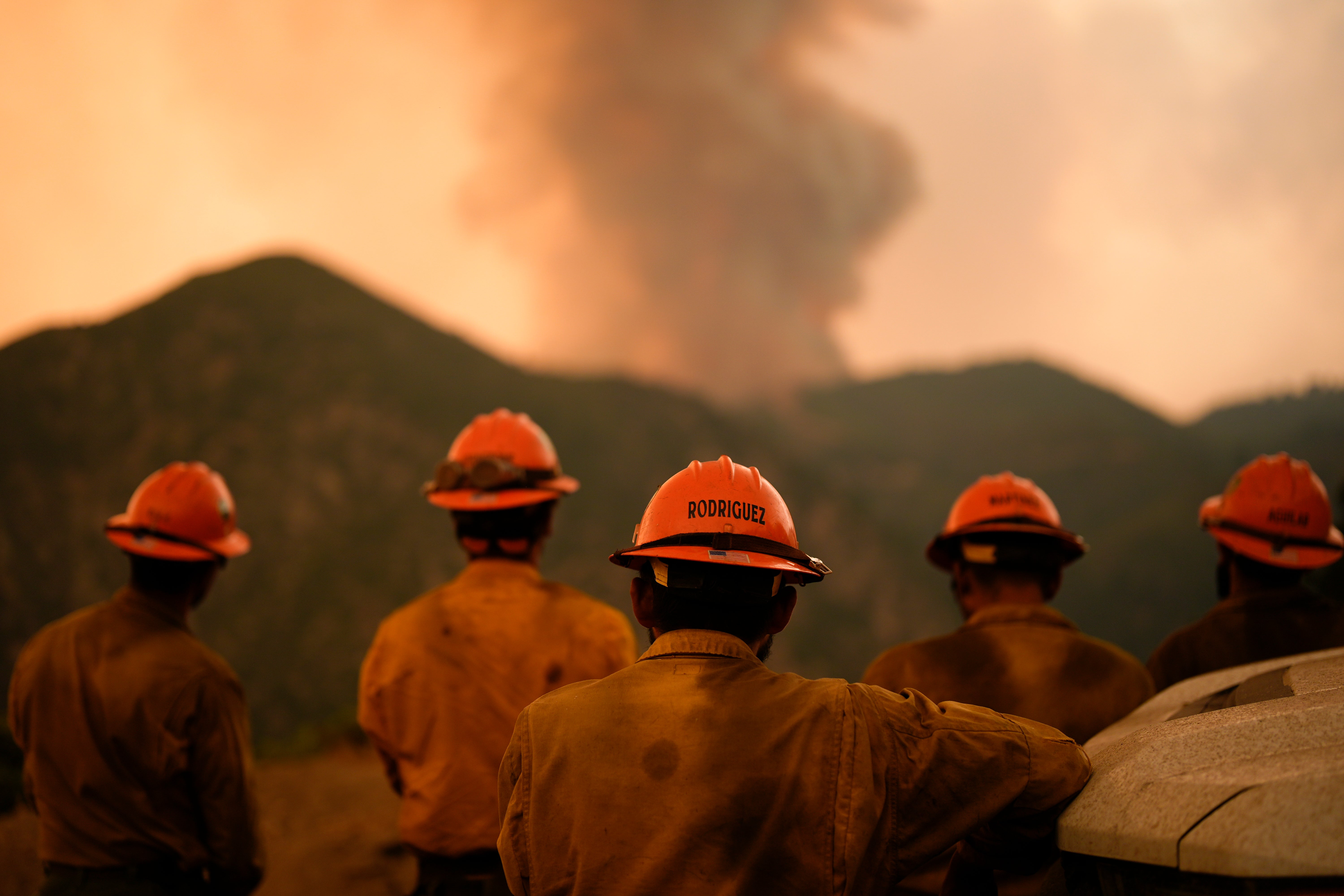 Firefighters monitor the Line Fire, which is burning through Southern California. A 34-year-old man has been arrested on arson charges in connection with the blaze