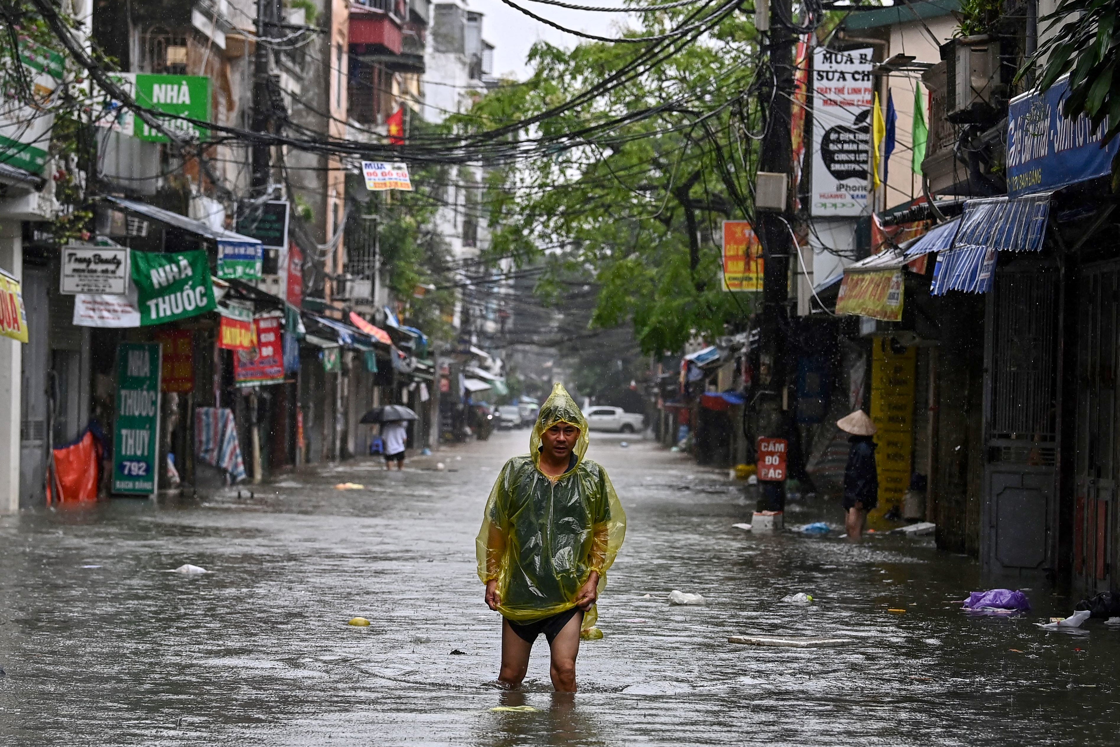 A man wades through a flooded street in Hanoi, Vietnam, on 11 September 2024.