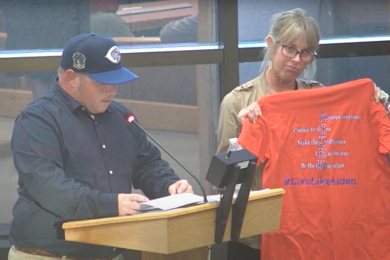 Nathan Clark and Danielle Clark hold up a shirt that says “Live Like Aiden” at the Springfield City Commission meeting on Tuesday