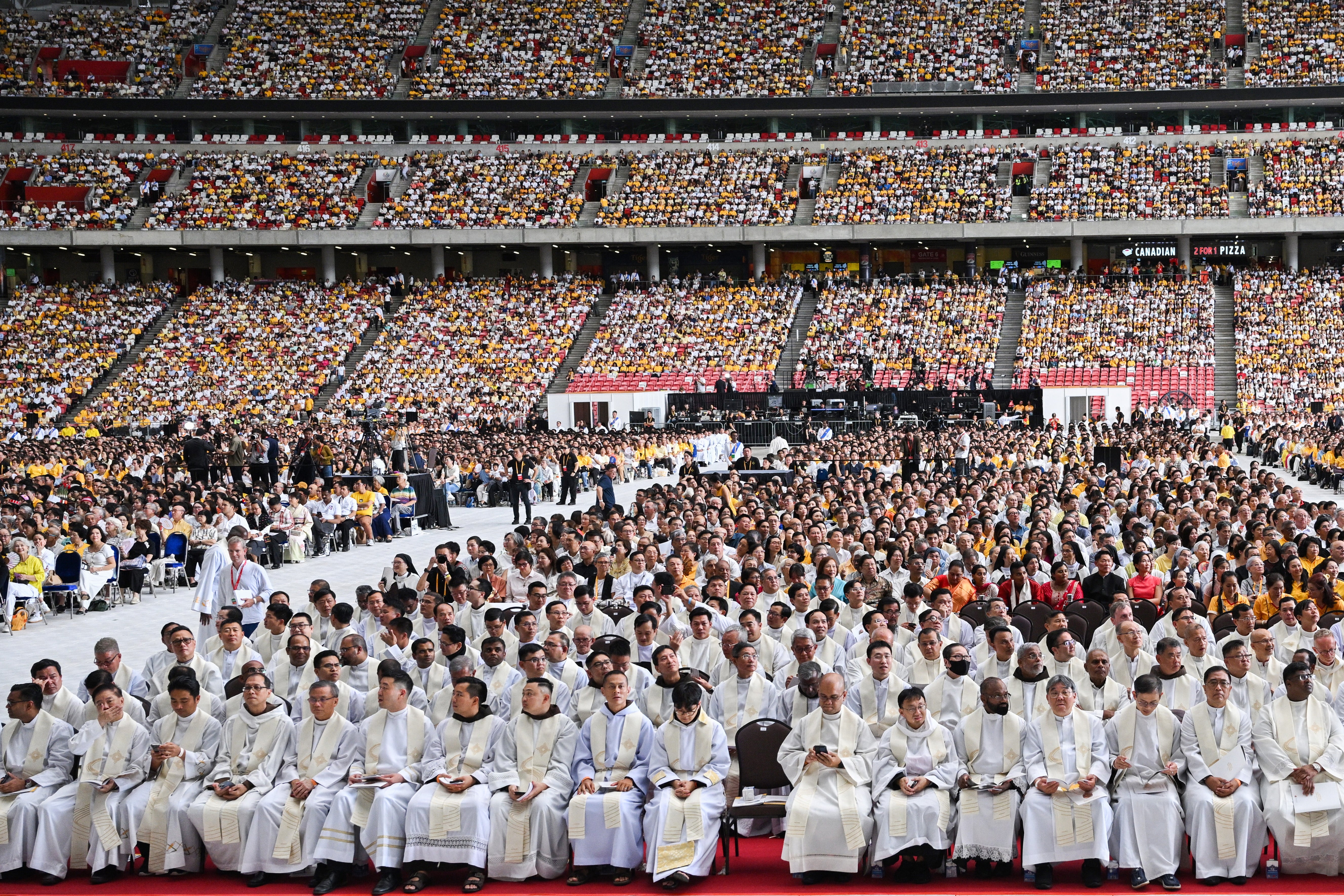 Catholic faithful attend a mass led by Pope Francis at the National Stadium in Singapore on 12 September 2024