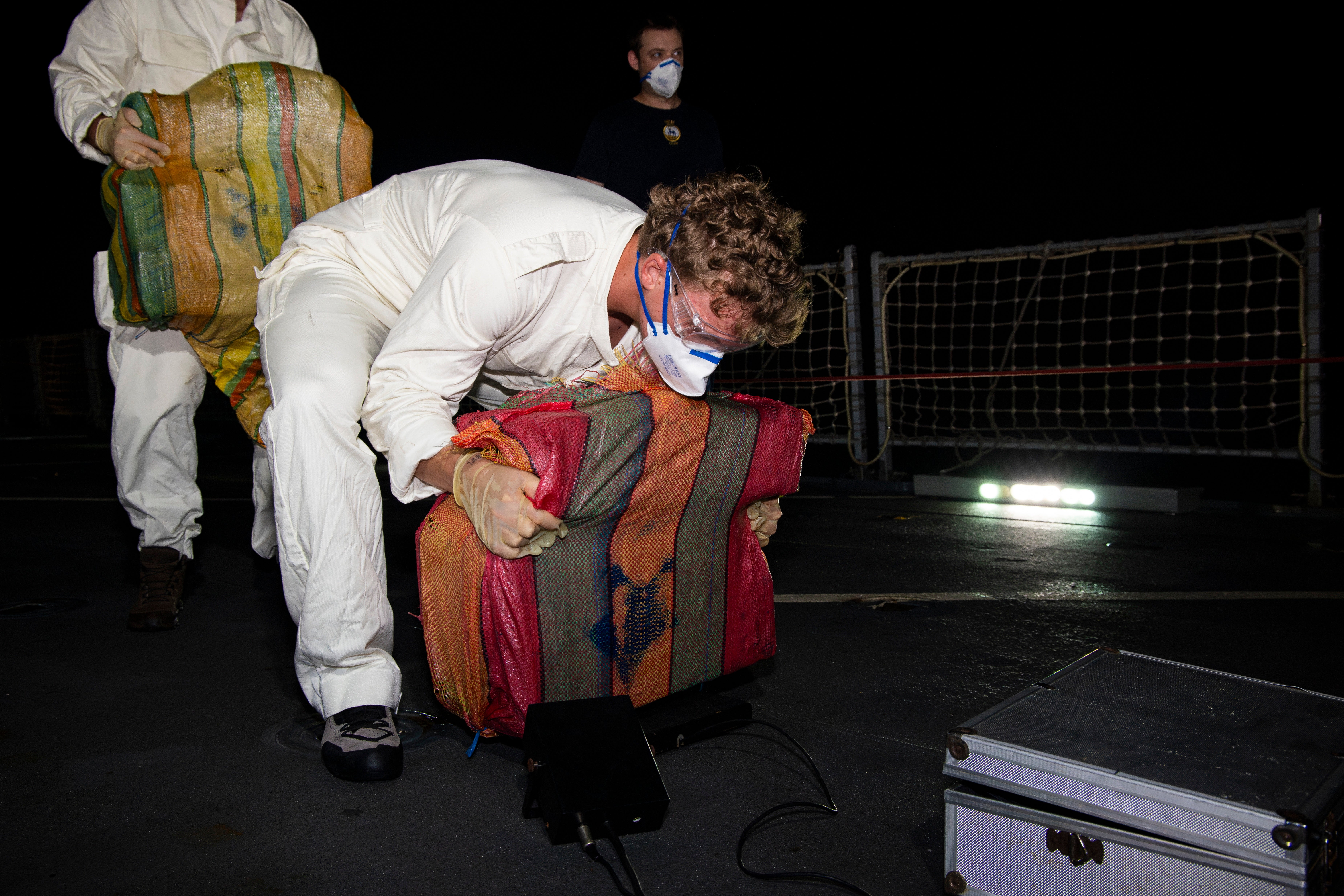 Cocacine seized from a narco-sub in the Caribbean Sea is weighed by a member of the crew aboard Royal Navy patrol ship HMS Trent