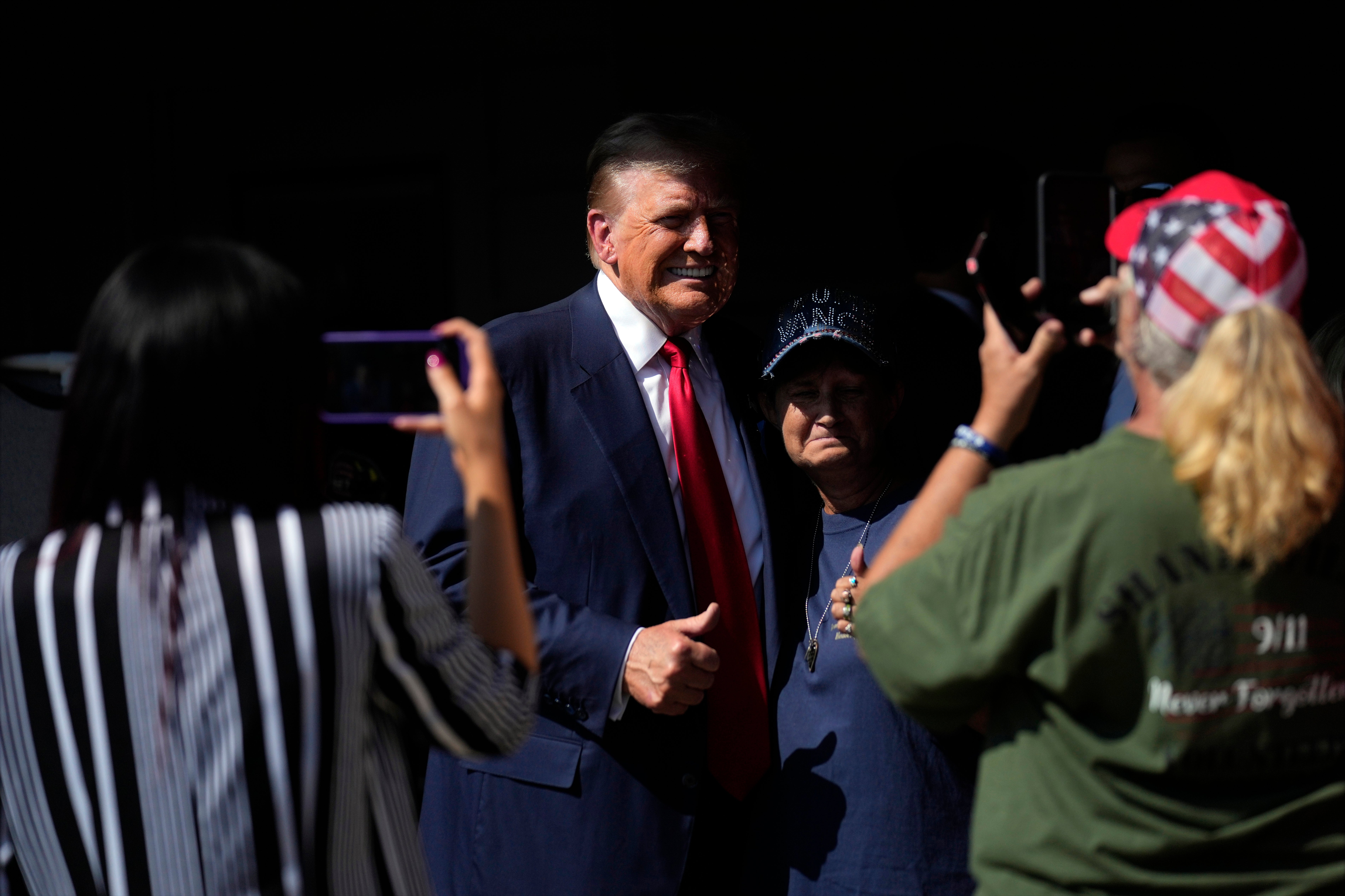 Loomer, left, snaps a photo as Donald Trump visits the Shanksville Volunteer Fire Company in Pennsylvania to mark the anniversary of the 9/11 terrorist attacks