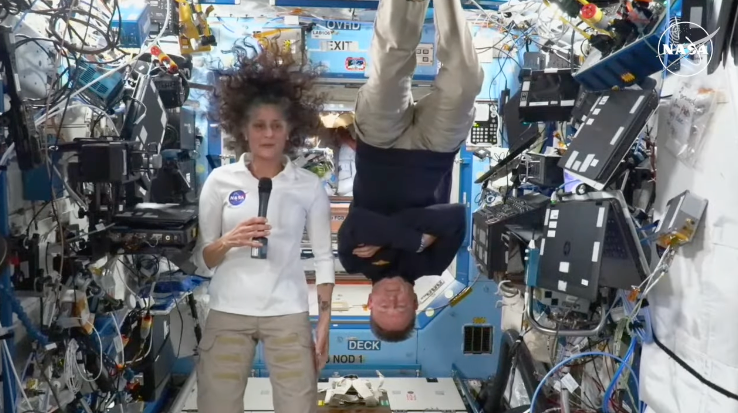 NASA astronaut Sunisa “Suni” Williams Barry talks into a microphone as “Butch” Wilmore does a flip while onboard the space station on Friday. The pair reaffirmed their commitment to NASA.