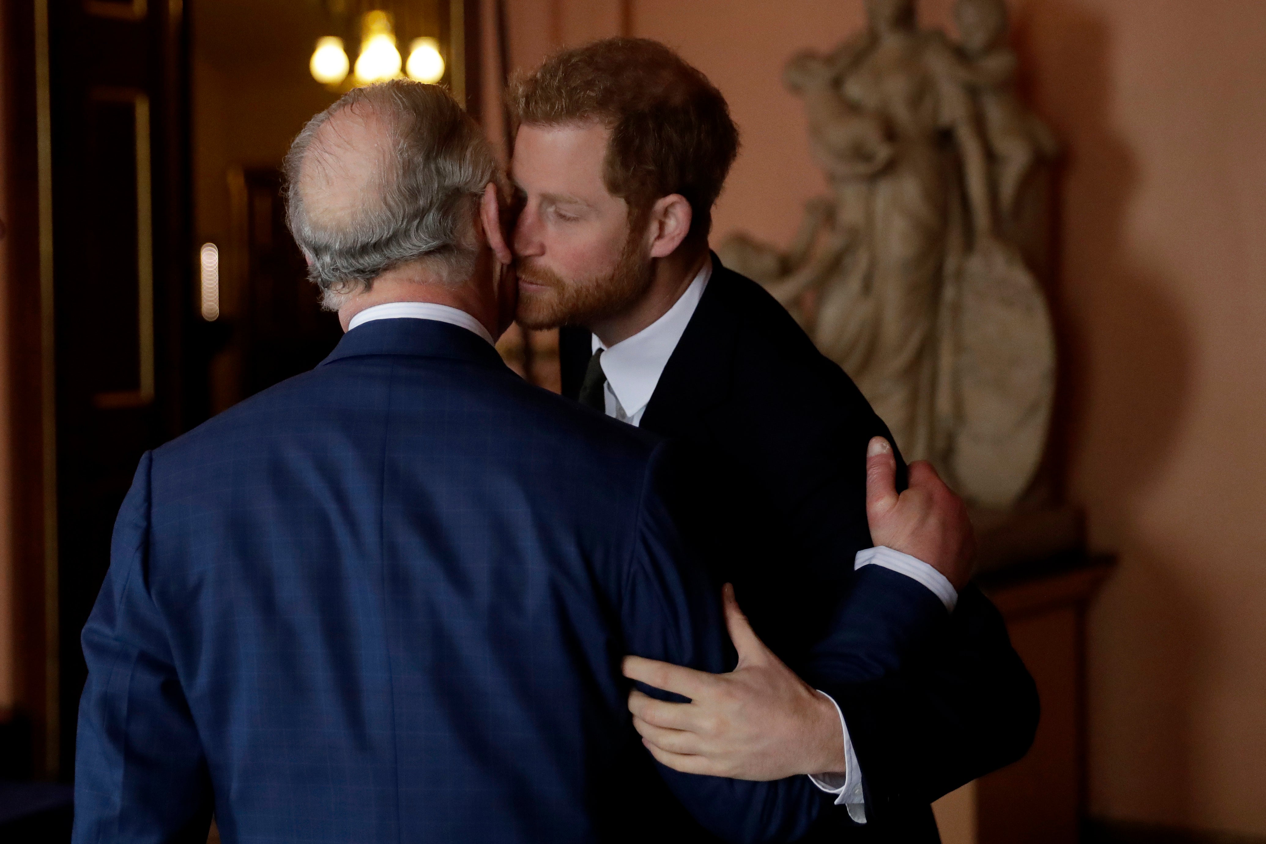 Prince Harry kisses and greets his father Prince Charles upon their separate arrival to attend a coral reef health and resilience meeting with speeches and a reception with delegates at Fishmongers Hall in London, Wednesday, Feb. 14, 2018