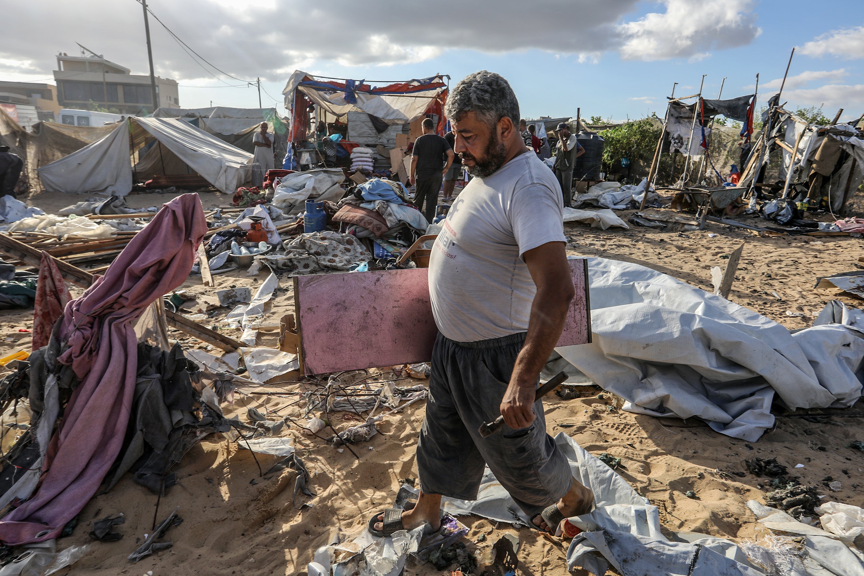 A Palestinian man searches for his belongings following an airstrike on tents in al-Mawasi area, Khan Yunis