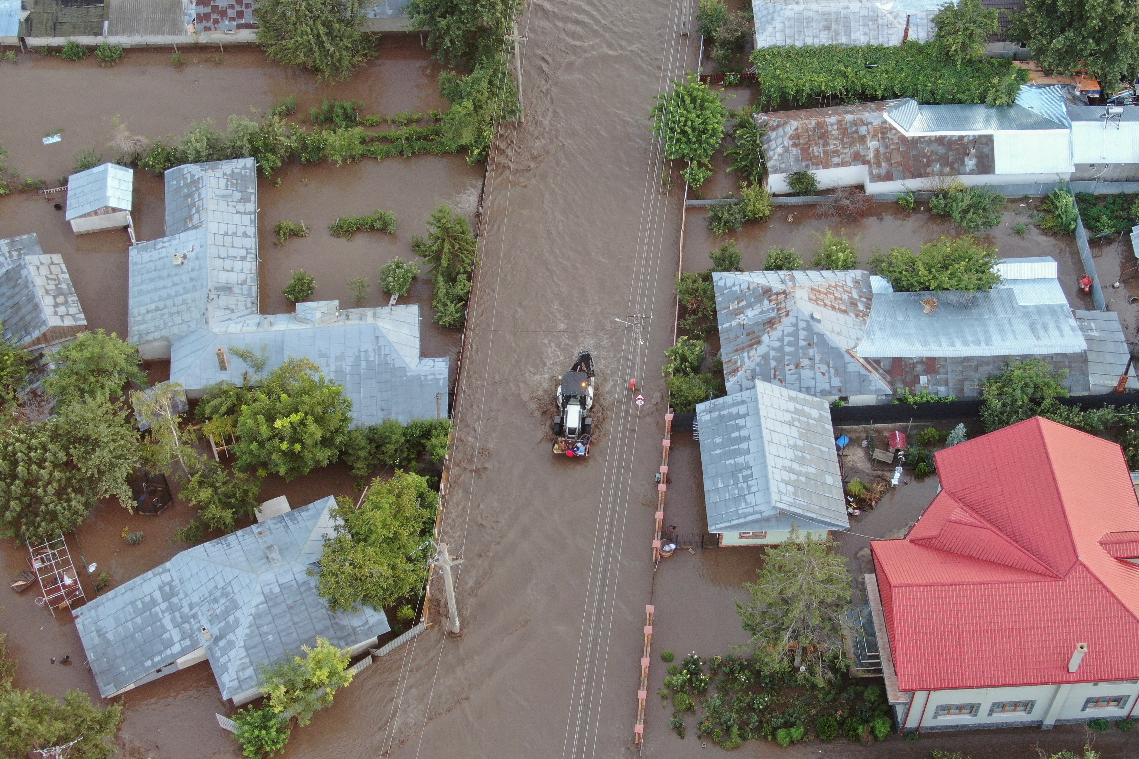 A drone view shows a tractor driving down a flooded road after heavy rain triggered flooding in Slobozia Conachi, Galati country, Romania