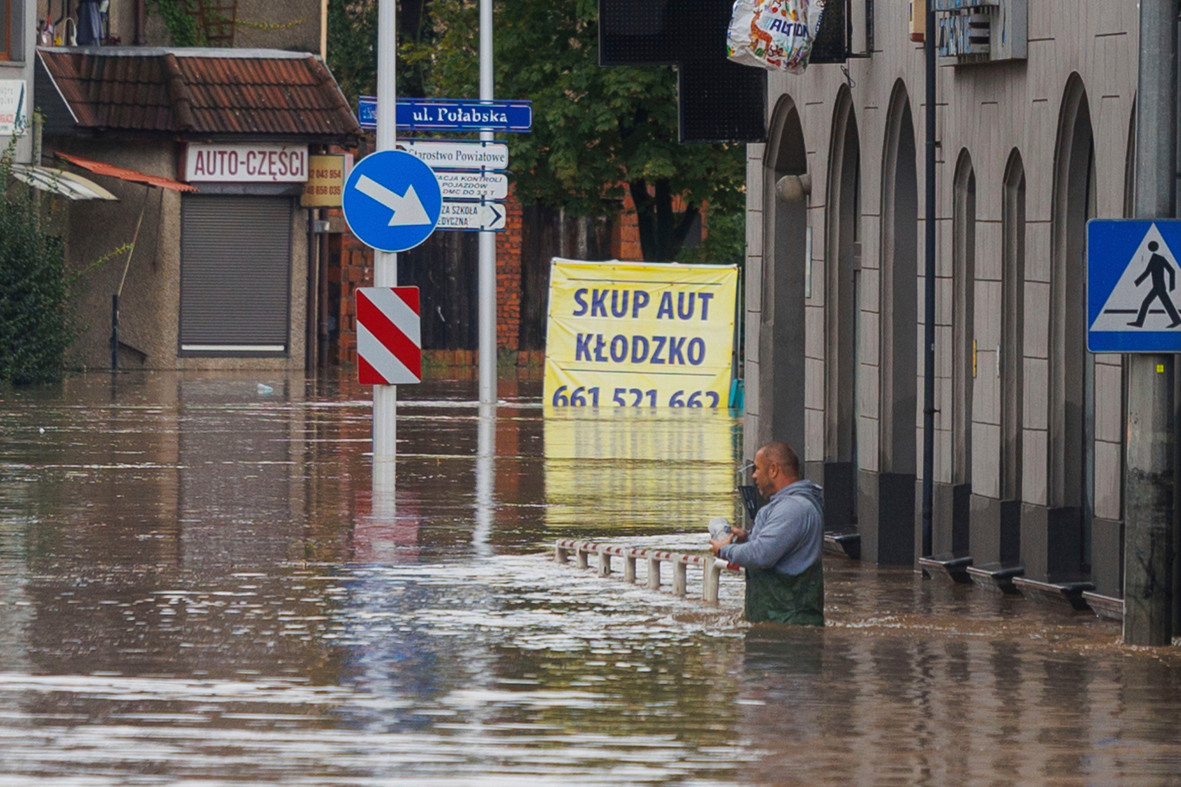 A man stands in waist-deep water in Kłodzko, in Poland’s southwest