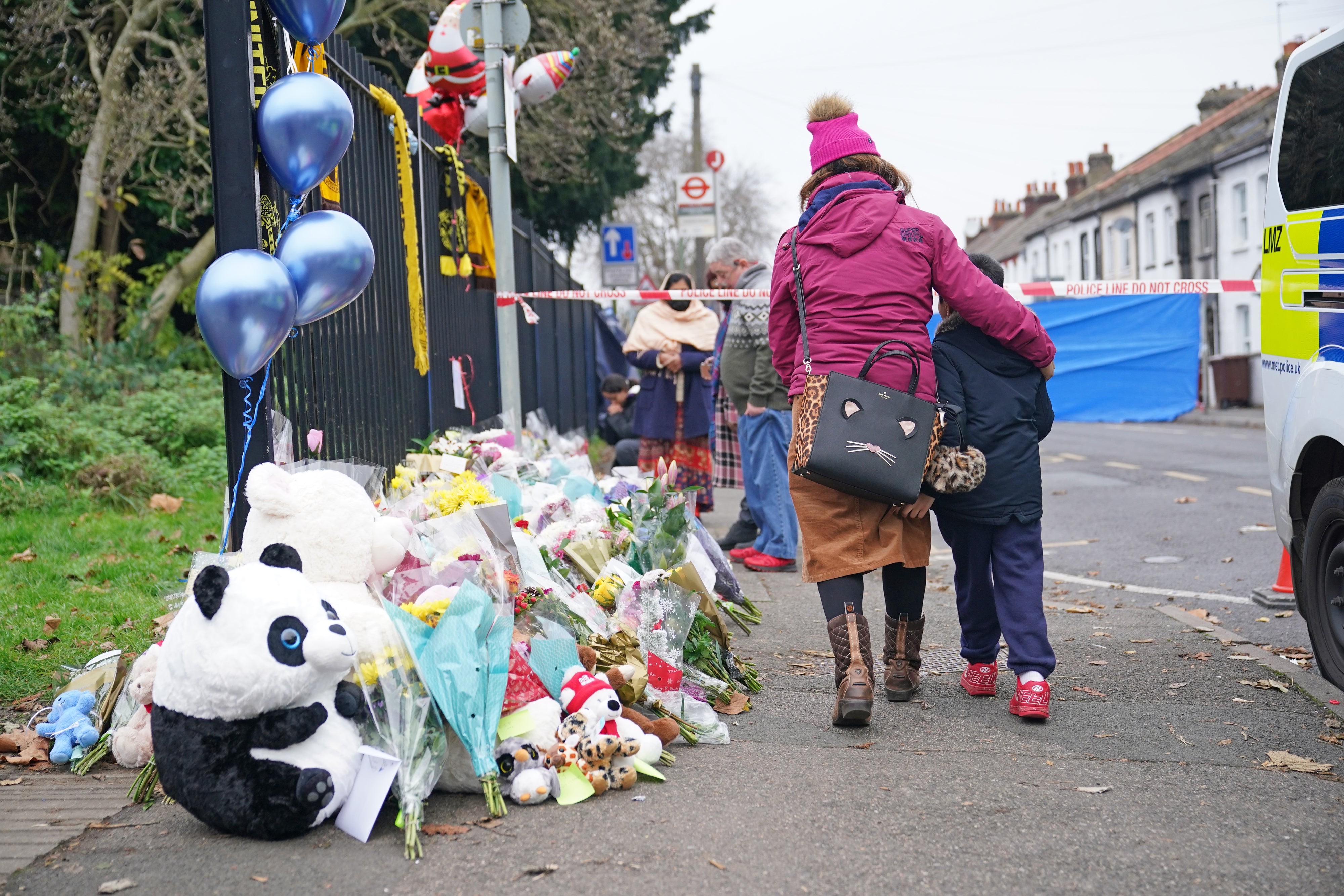 Flowers and toys are left near the scene of the fire in Sutton, south London (Yui Mok/PA)