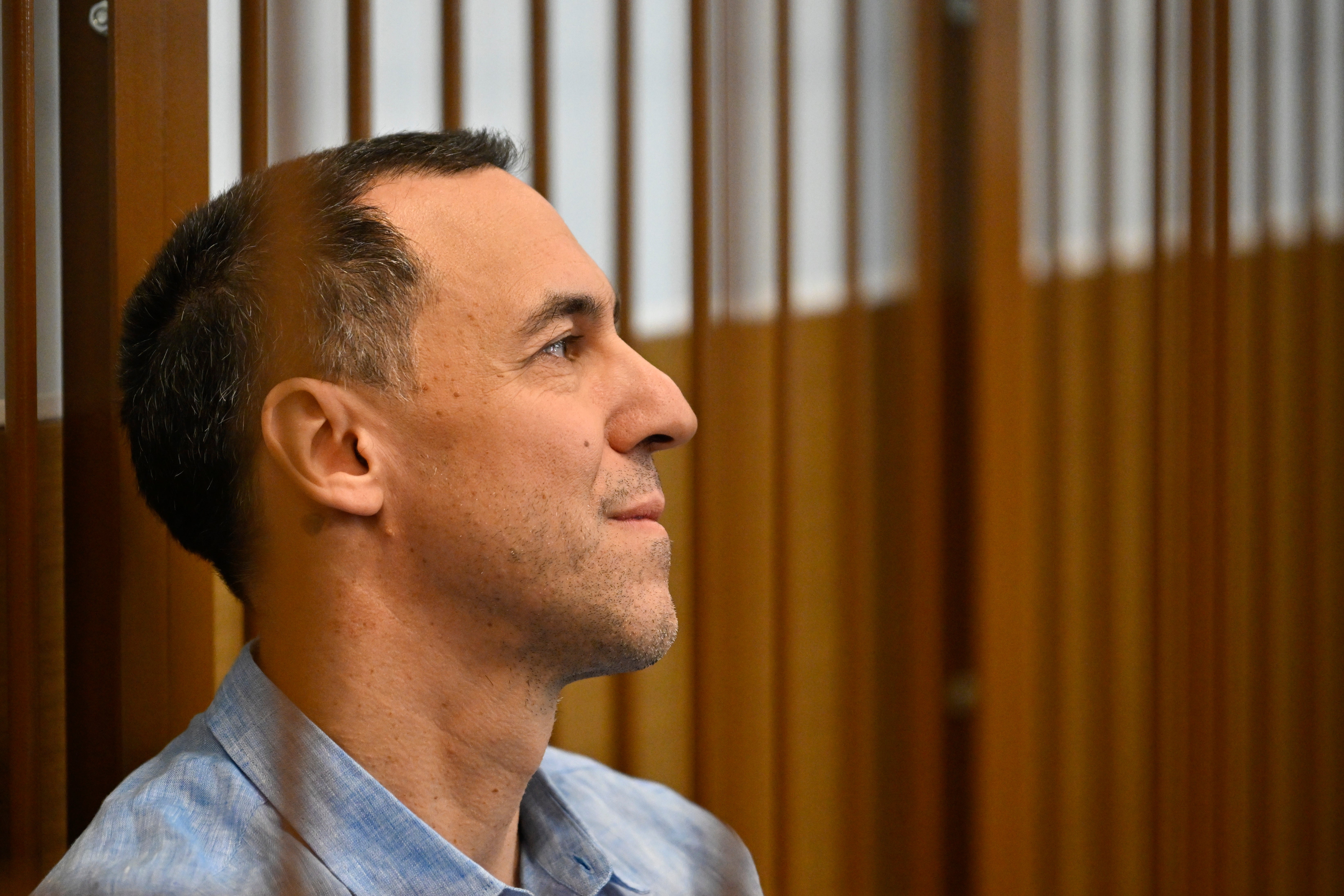 French citizen Laurent Vinatier sits in a cage in a courtroom in the Zamoskvoretsky District Court