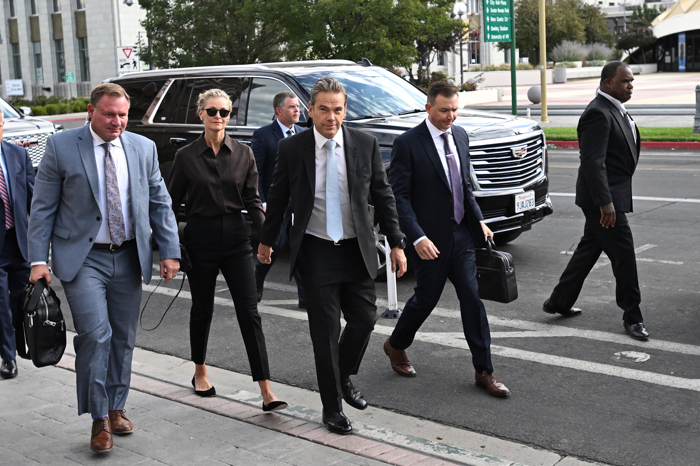 Lachlan Murdoch, center, and his wife Sarah arrive at the Second Judicial District Court in Reno