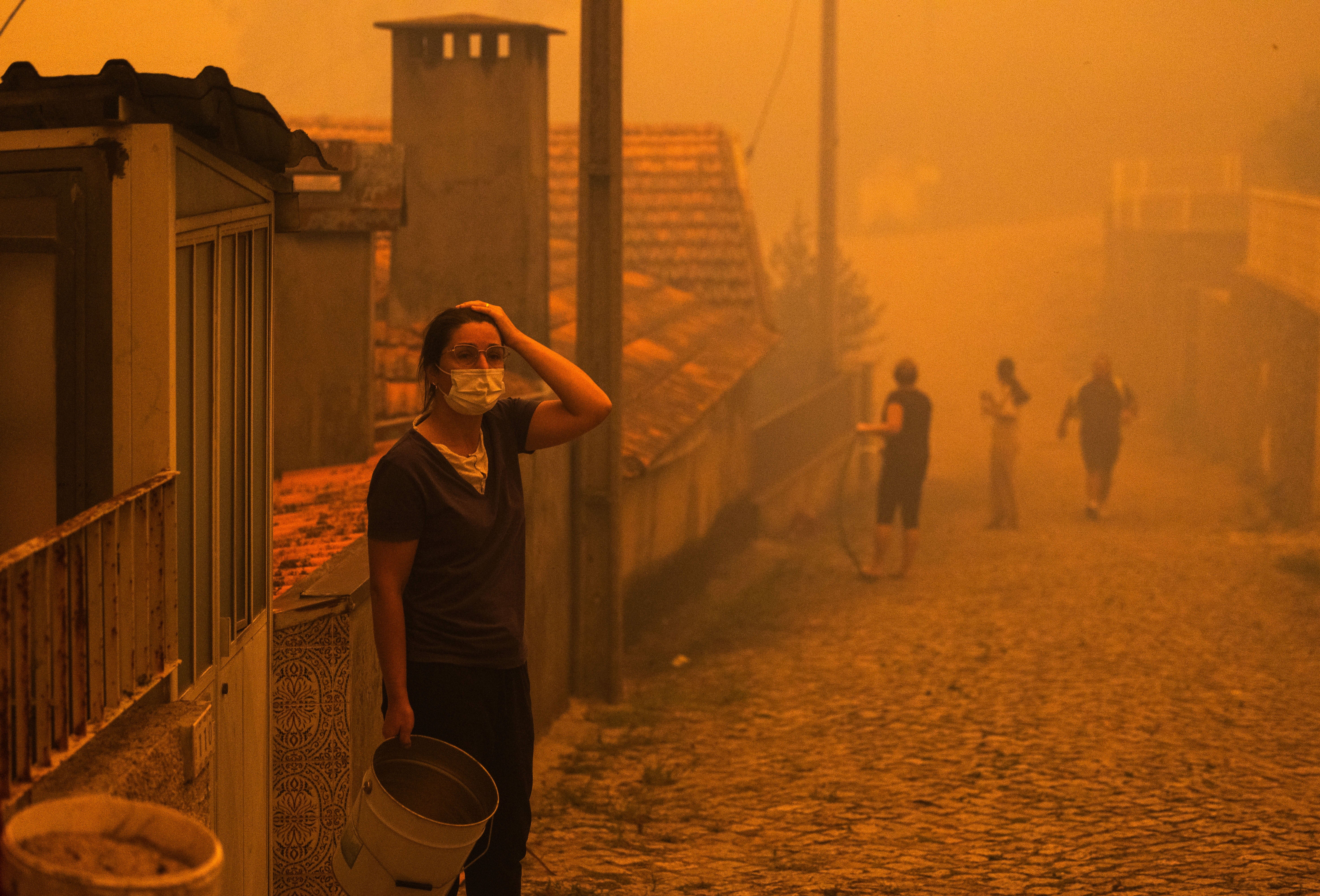 A woman reacts next her home in Covelo, Gondomar, northern Portugal, 17 September 2024