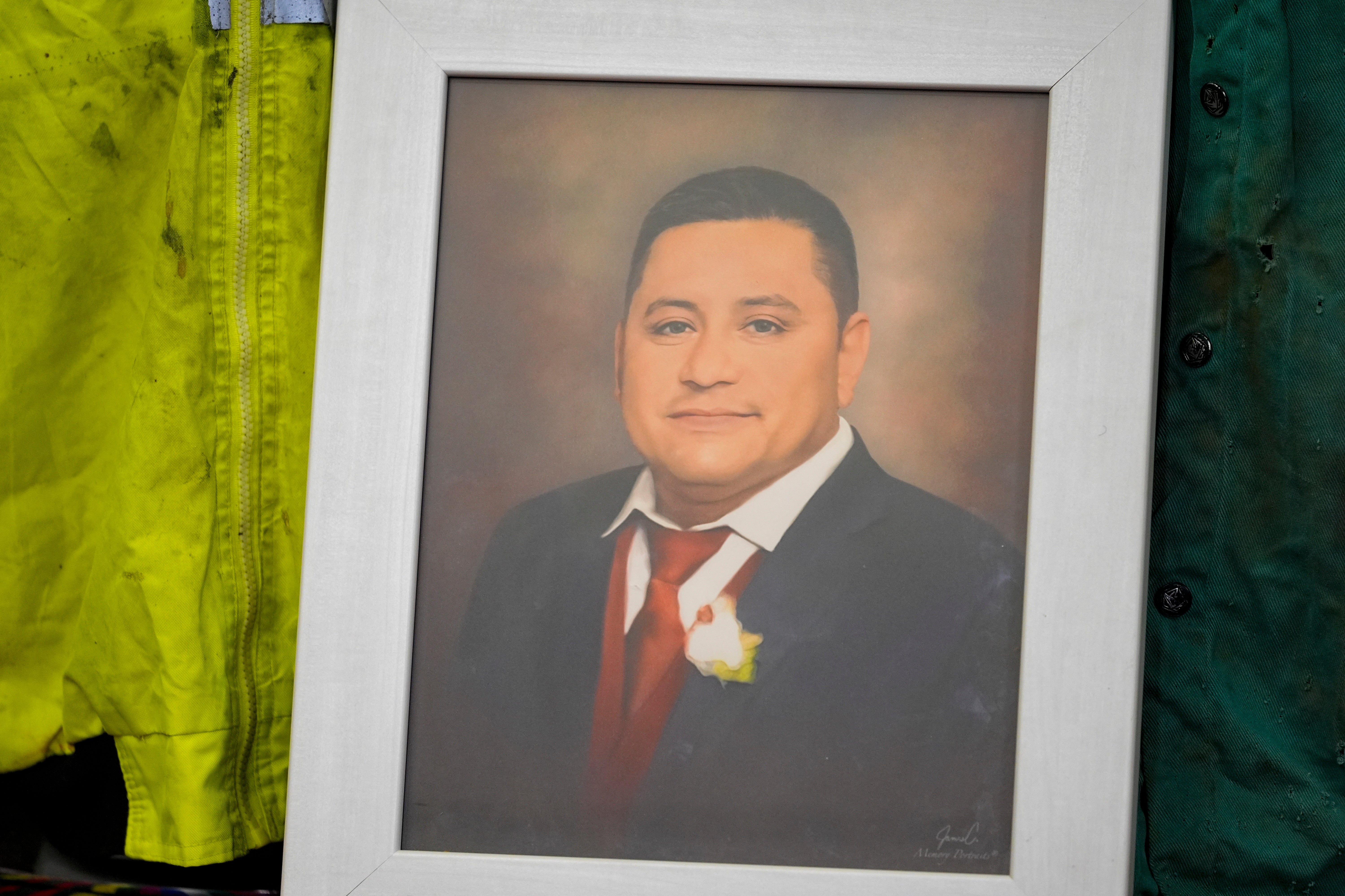 A portrait of Miguel Luna, a worker who died during the collapse of Baltimore's Francis Scott Key Bridge, is displayed among articles of his welding gear during a news conference on Tuesday