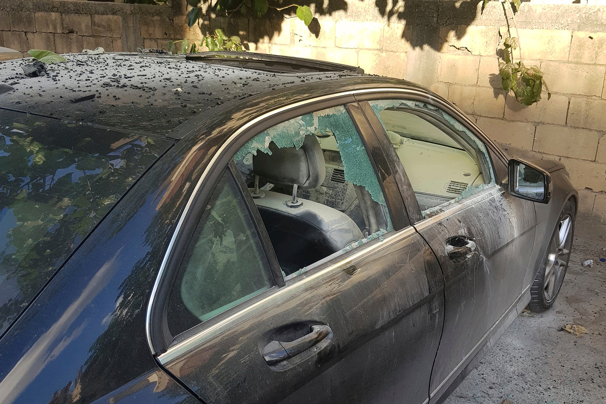 A partly damaged car after what is believed to be the result of a walkie-talkie exploding inside it in the southern port city of Sidon, Lebanon, on Wednesday