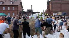 Volunteers create human chain to distribute sandbags in Poland during severe flooding