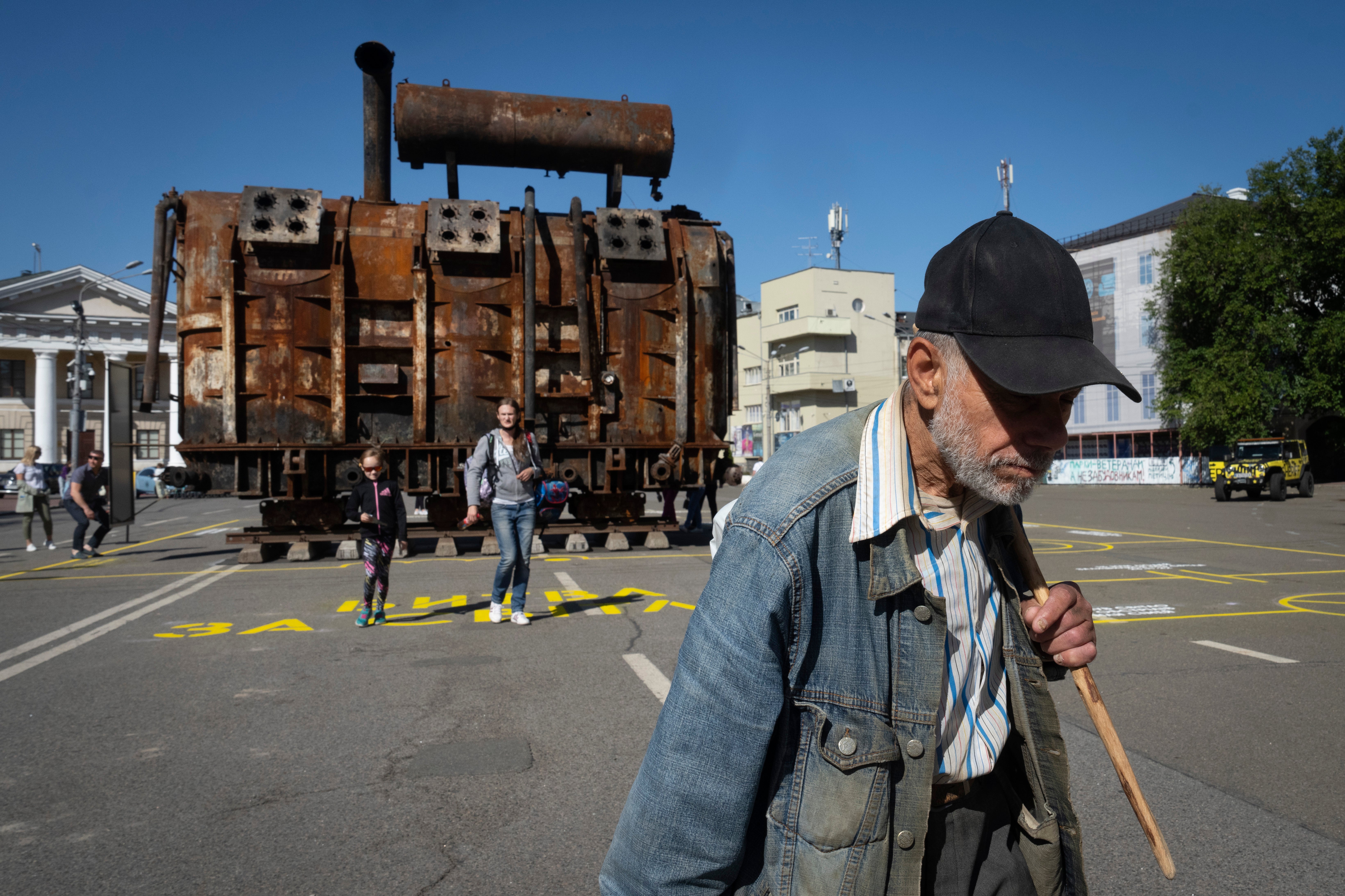 A man passes by a burnt transformer badly damaged in one of Russia's recent missile attacks on energy system in Kyiv on September 19