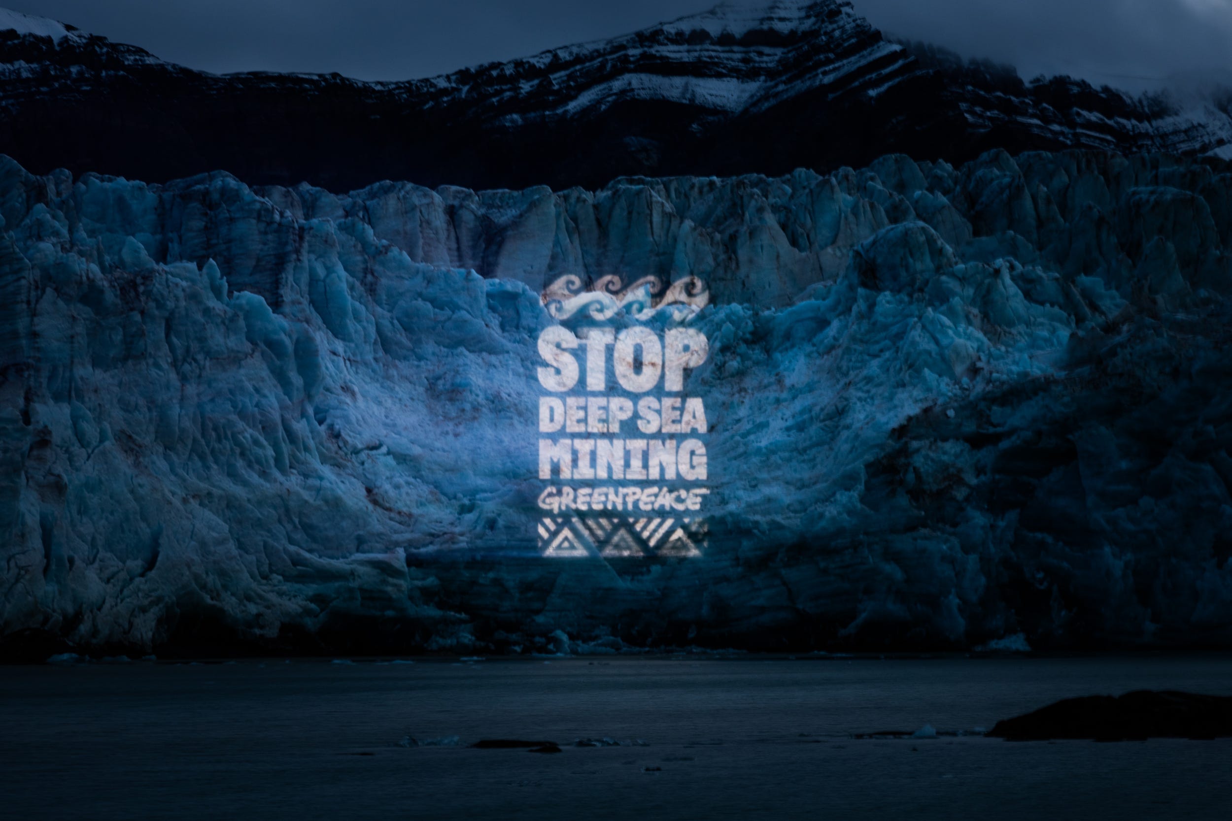 Light projection on glacier in the Arctic calling for a halt to deep sea mining (Bianca Vitale/Greenpeace/PA)