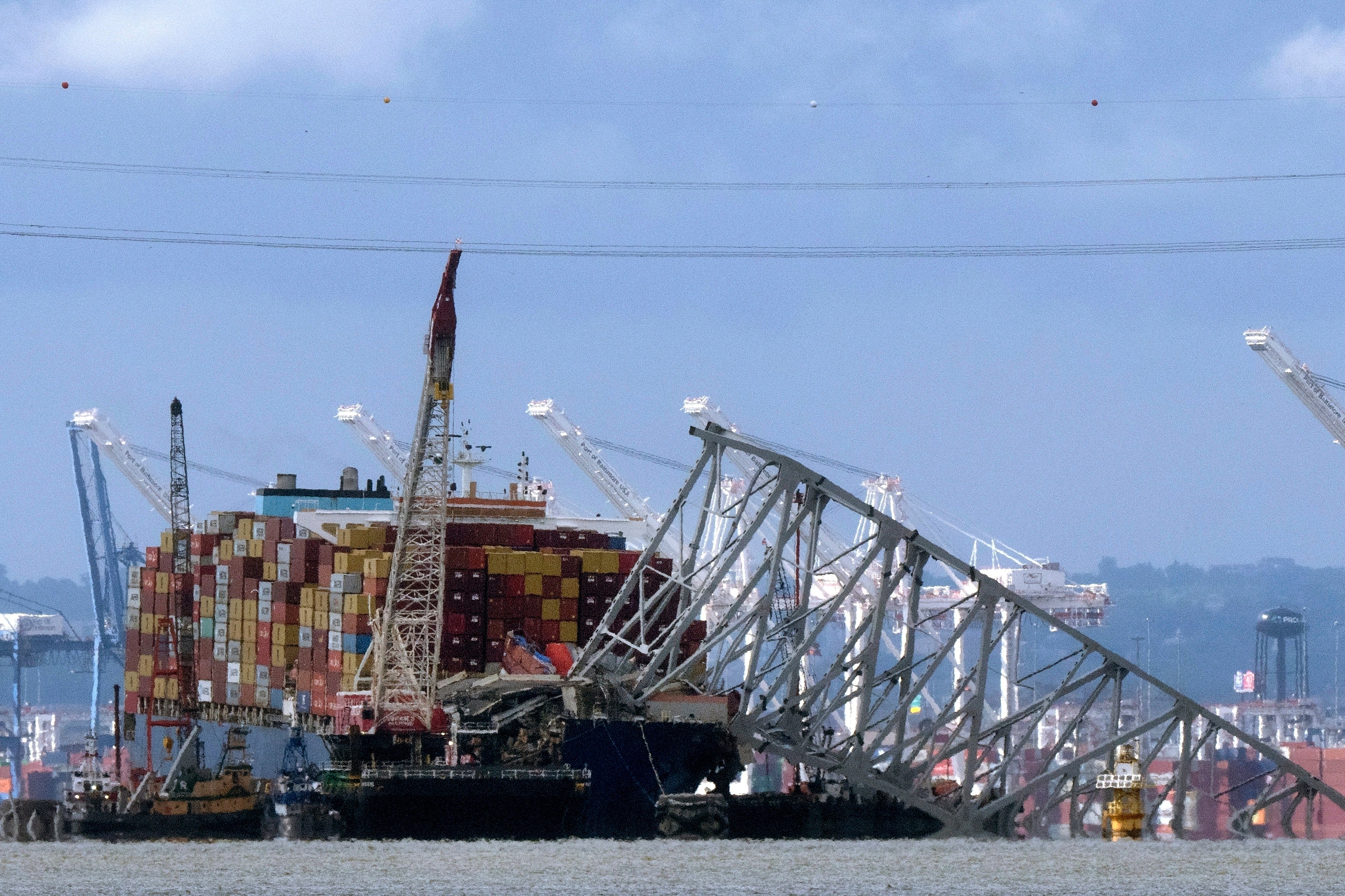 The collapsed Francis Scott Key Bridge rests on the container ship Dali, 12 May 2024, in Baltimore, as seen from Riviera Beach, Md