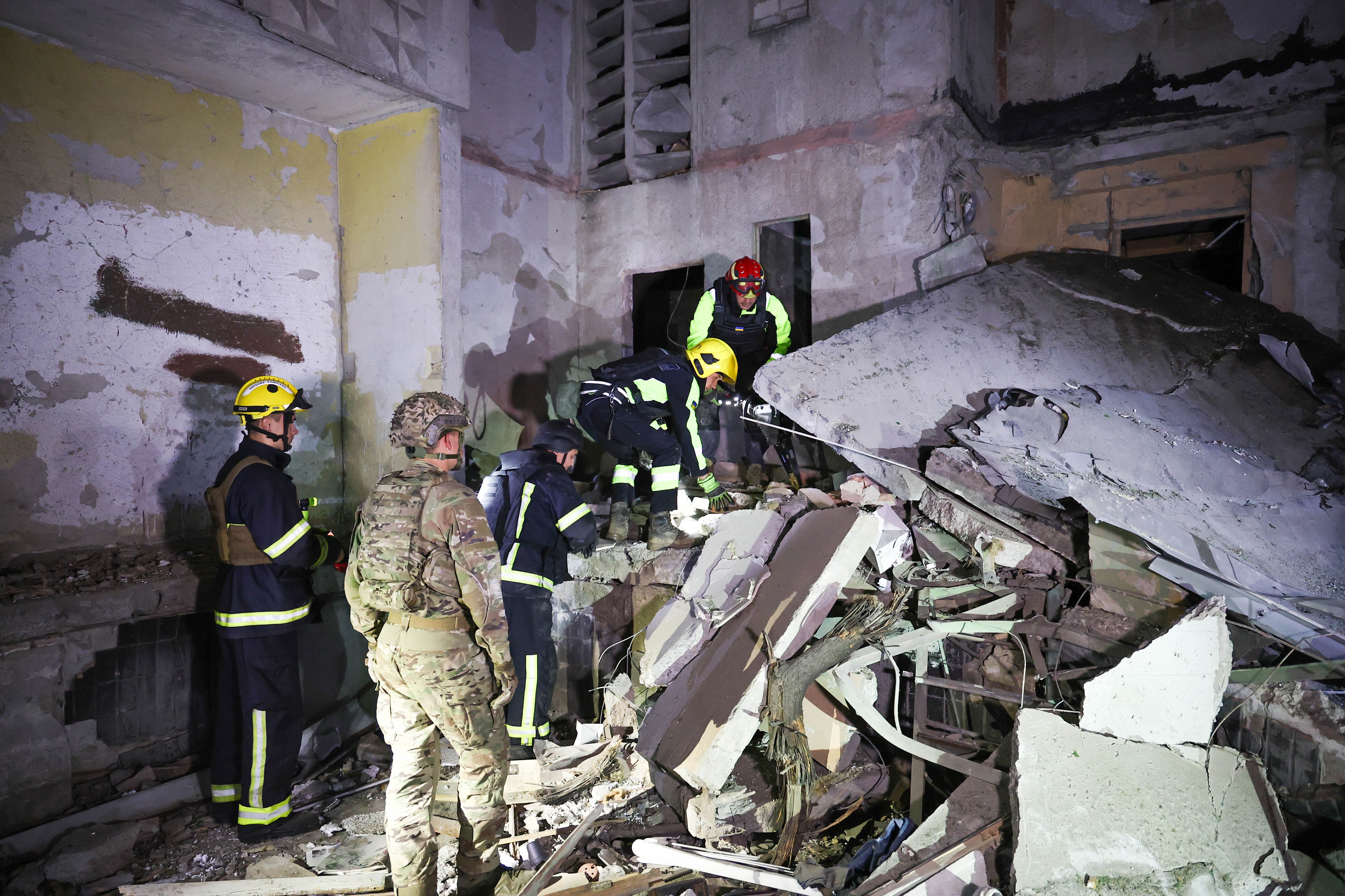 Ukrainian responders work at the sit of the overnight shelling