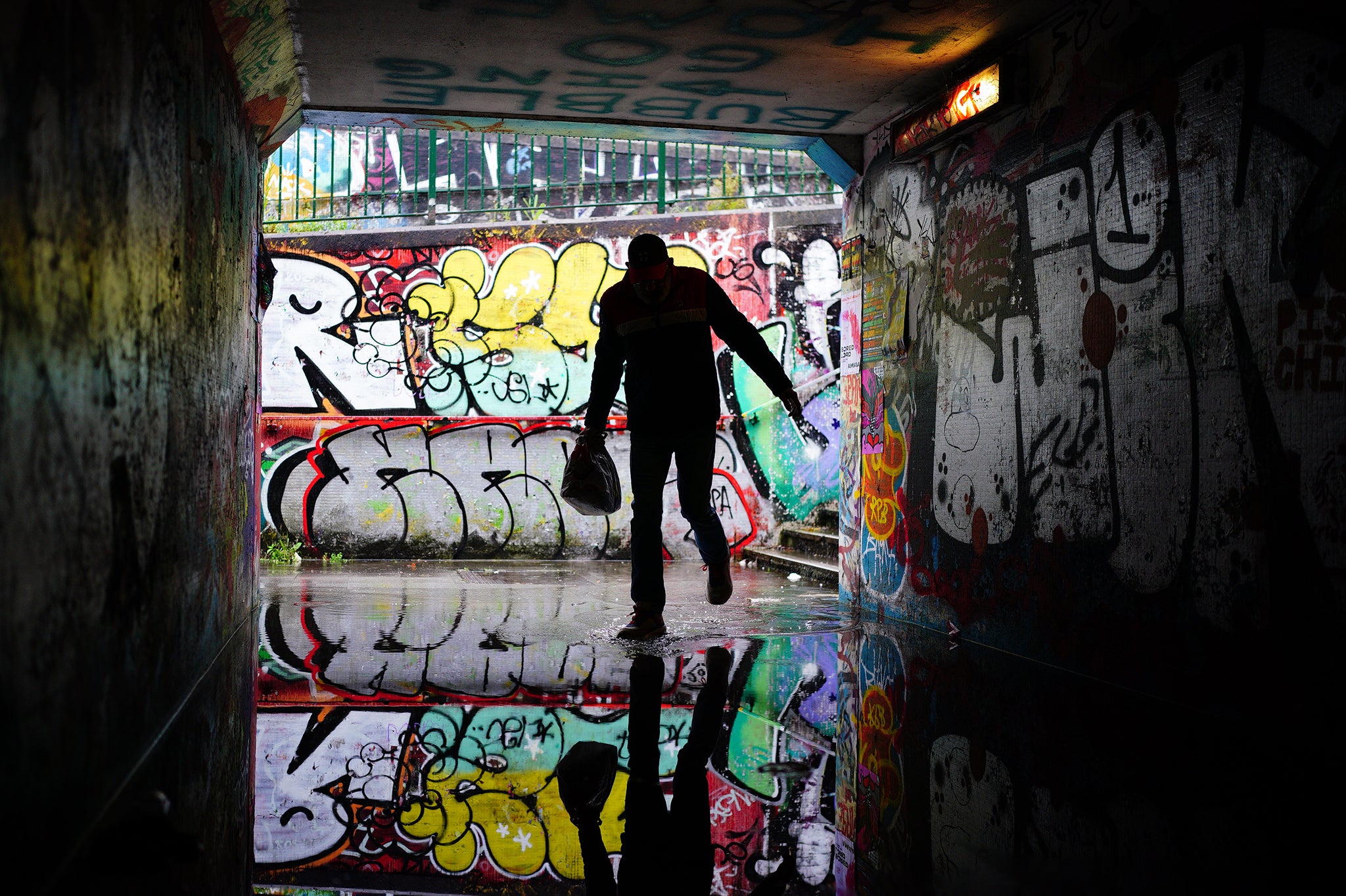 A person shelters from the rain in a flooded underpass by Lawrence Hill Roundabout, Bristol.