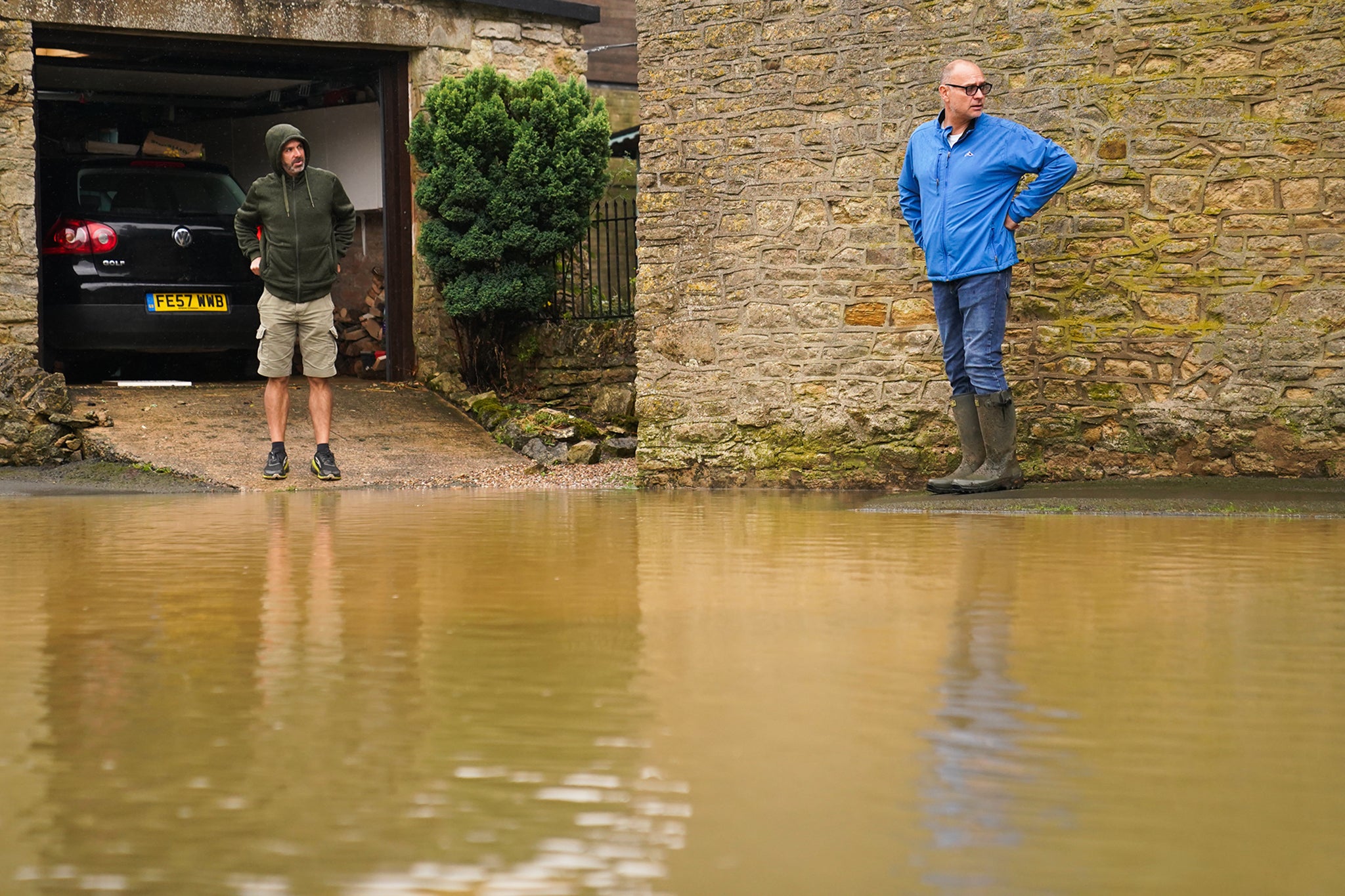 People looking at flood water in Grendon, Northamptonshire