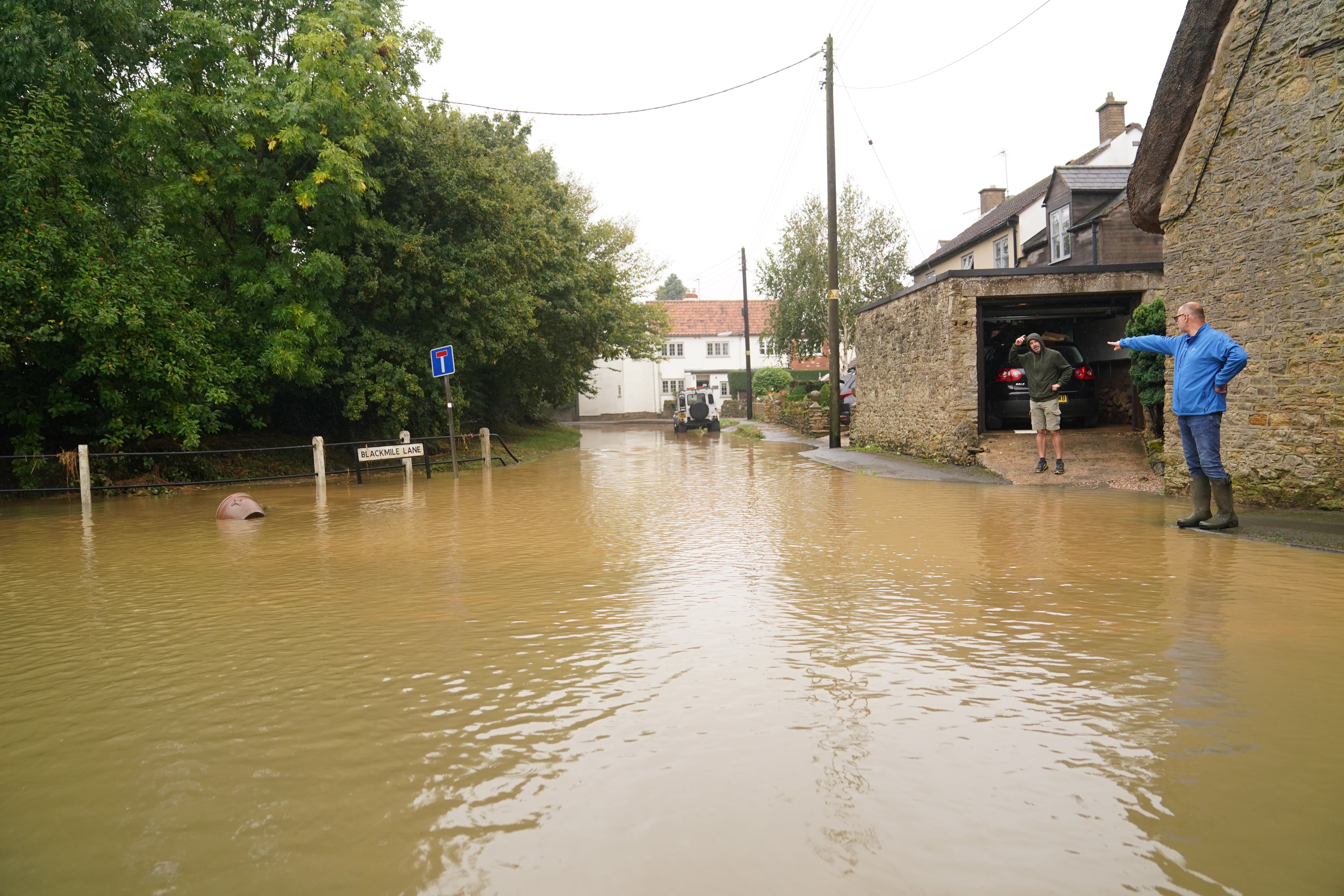 People looking at flood water in Grendon, Northamptonshire