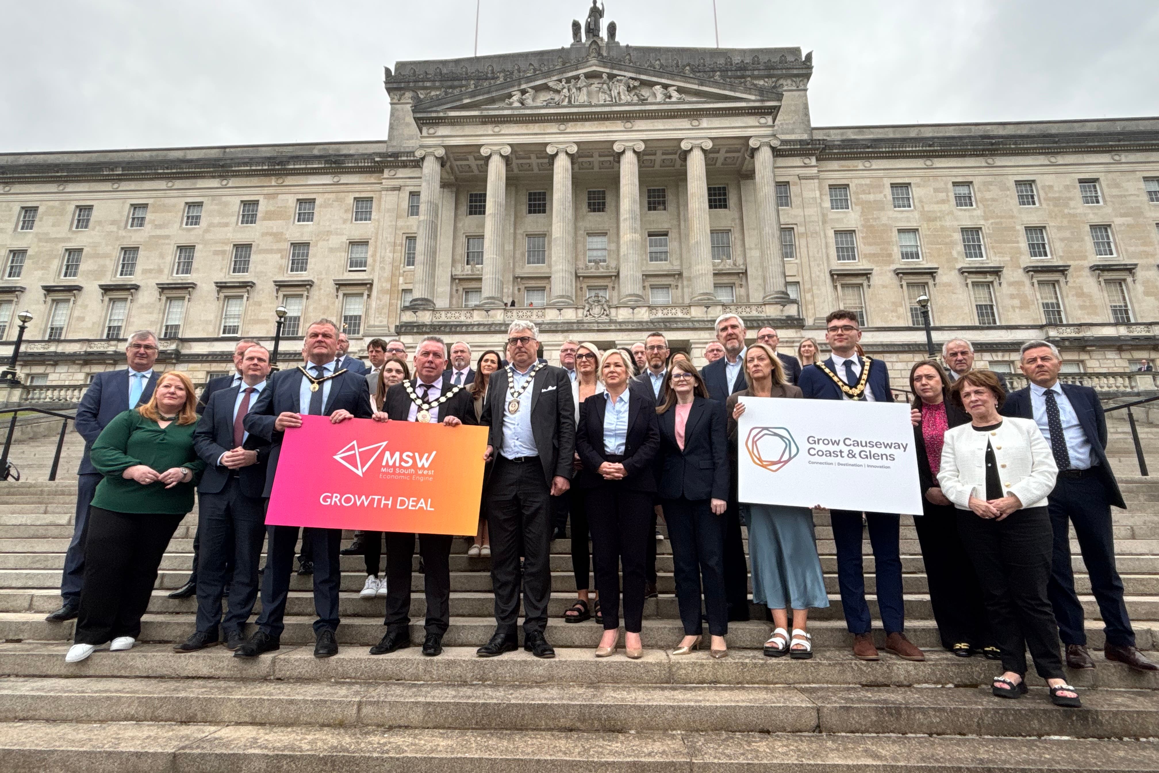 Stormont First Minister Michelle O’Neill (centre) and Finance Minister Caoimhe Archibald stand with partners from the Causeway Coast and Glens and Mid Southwest Growth Deals as they call for the lifting of a pause in funding to the deals by the UK Government (Rebecca Black/PA)