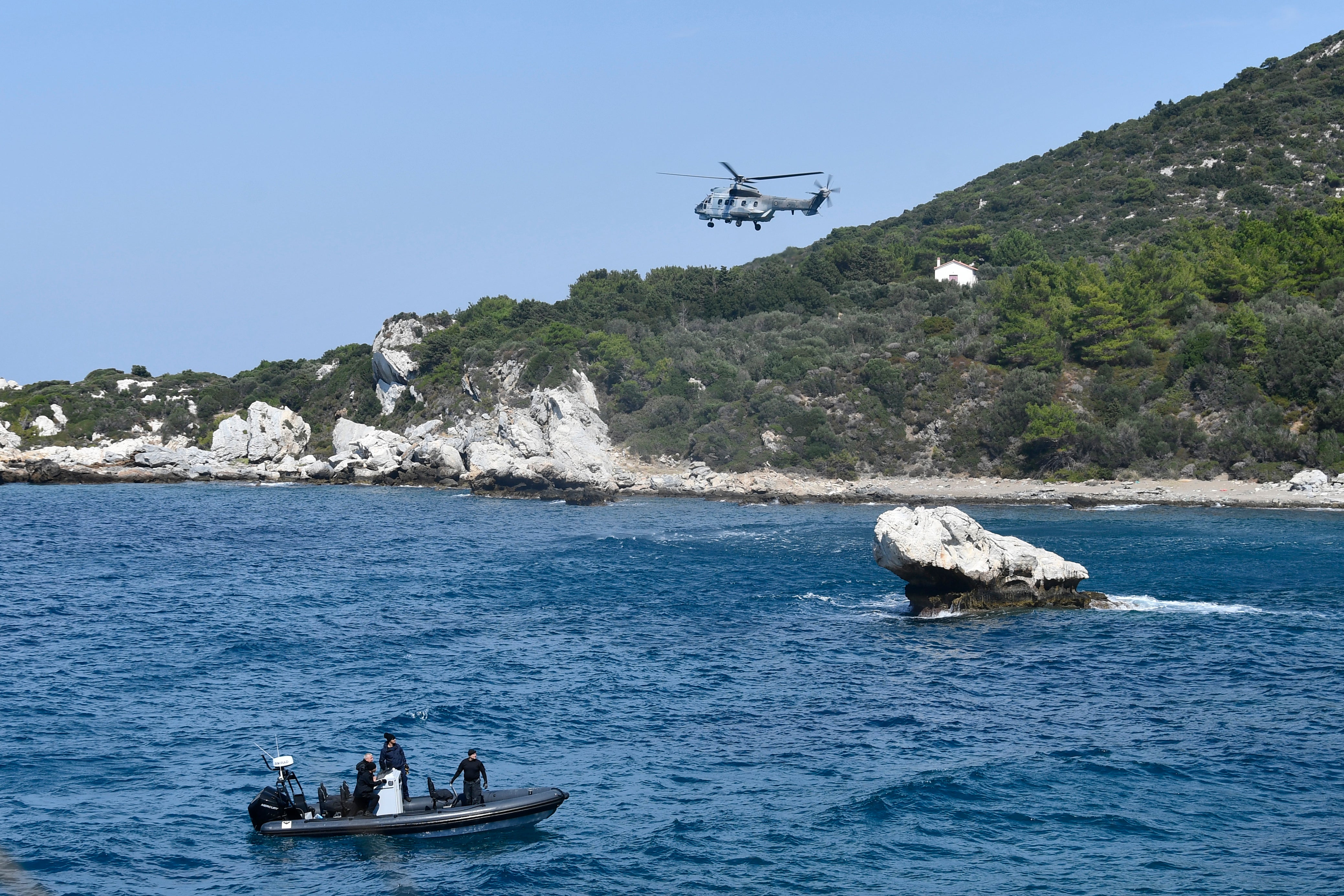 A helicopter and a vessel with coast guards officers take part in a search and rescue operation after a boat carrying migrants ran into trouble off the coast of the eastern Aegean Sea island of Samos, Greece, on Monday, Sept. 23, 2024