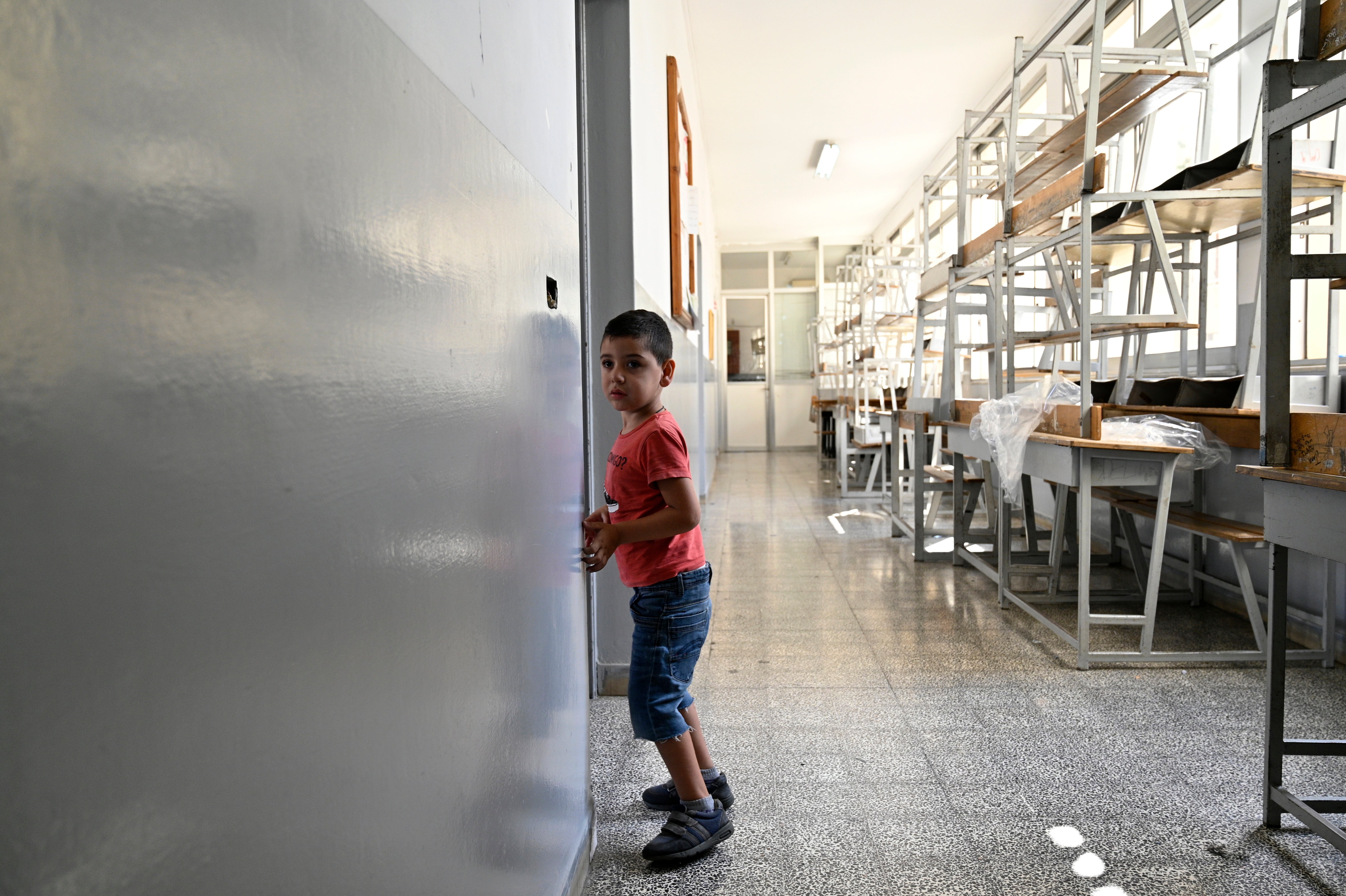 A child who fled southern Lebanon walks around a makeshift shelter at an educational institution in Beirut