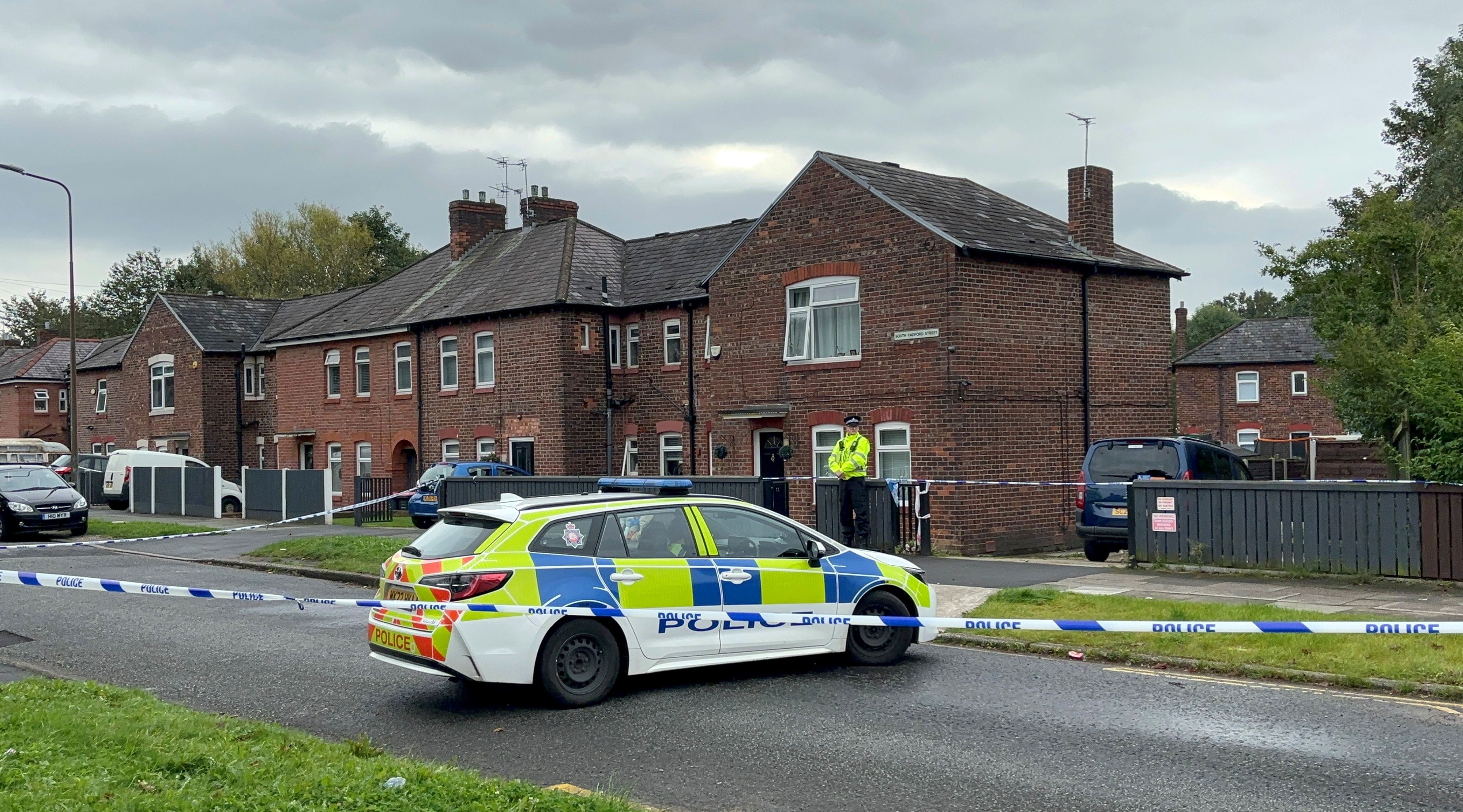 Police outside a house in Salford where an eight-year-old girl and a woman have been found dead